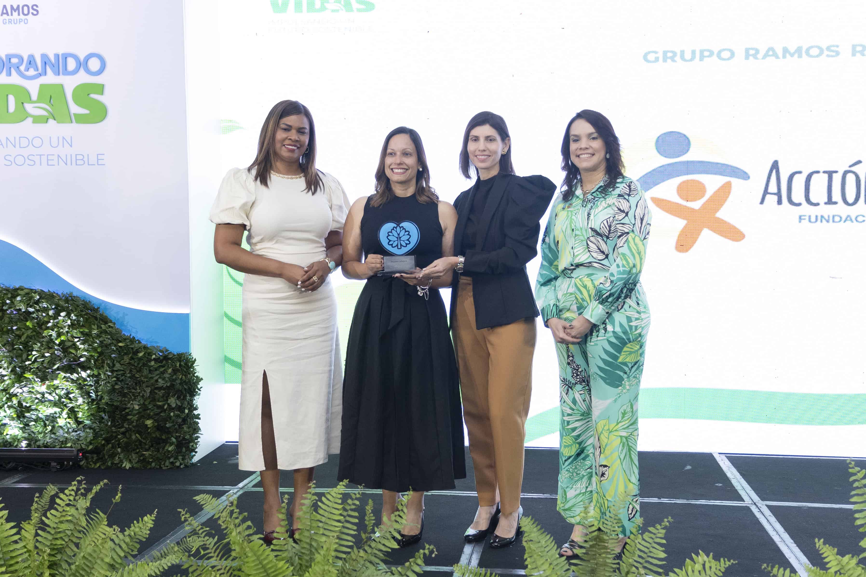 Entrega de reconocimiento a la representante de Acción Callejera (centro, izq).