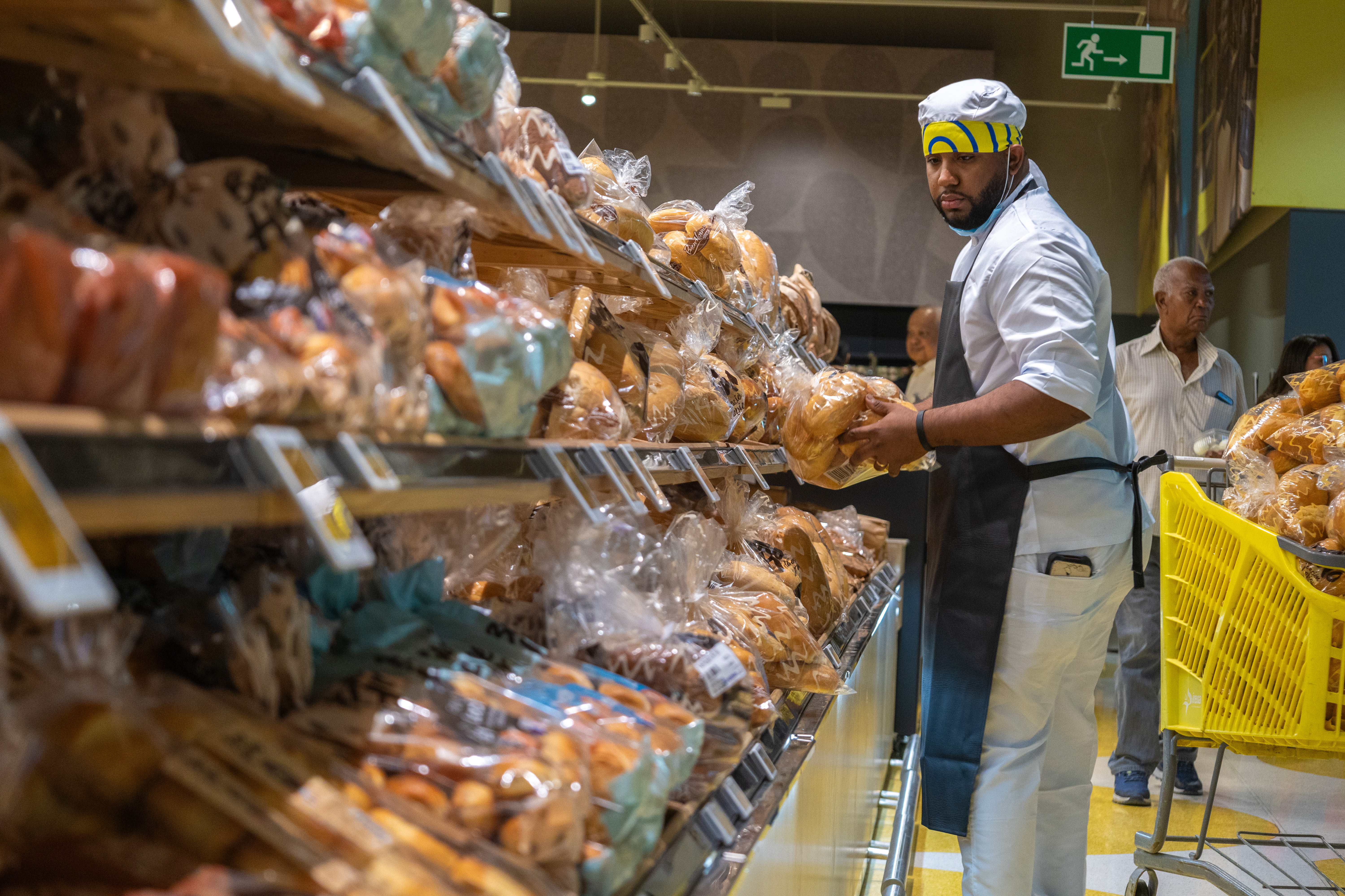 Un empleado coloca los panes en la góndola de uno de los pasillos renovados.