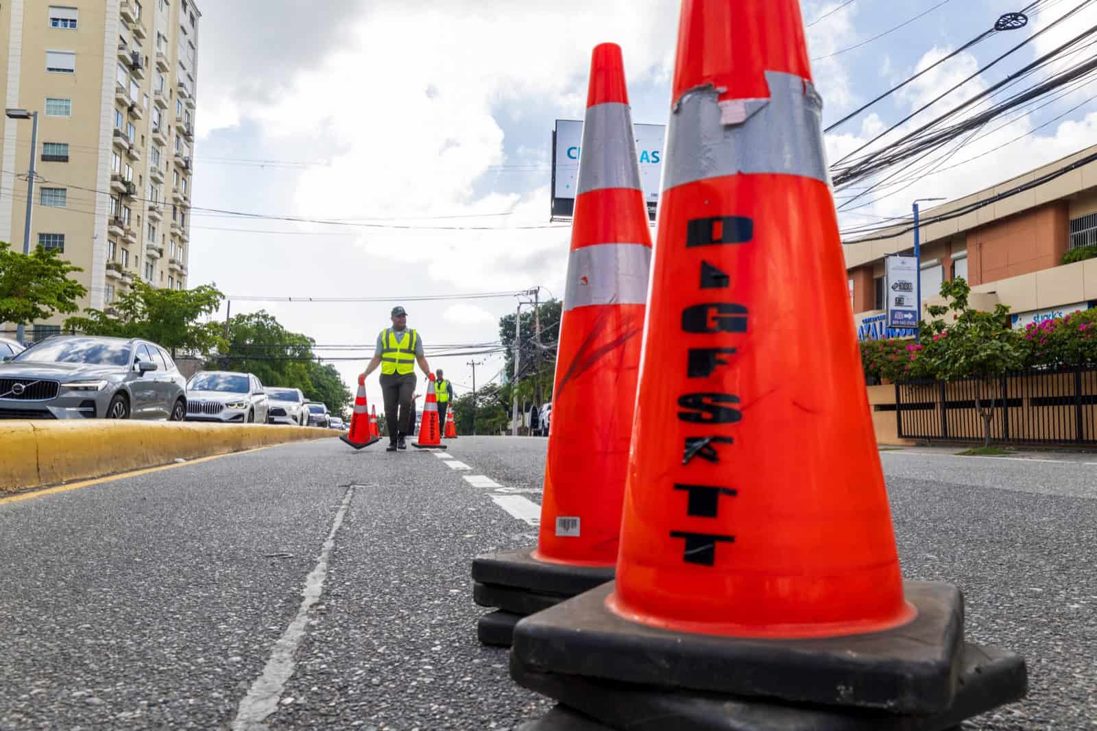 Un agente retira los cono de carriles temporales que permiten agilizar el flujo vehicular.