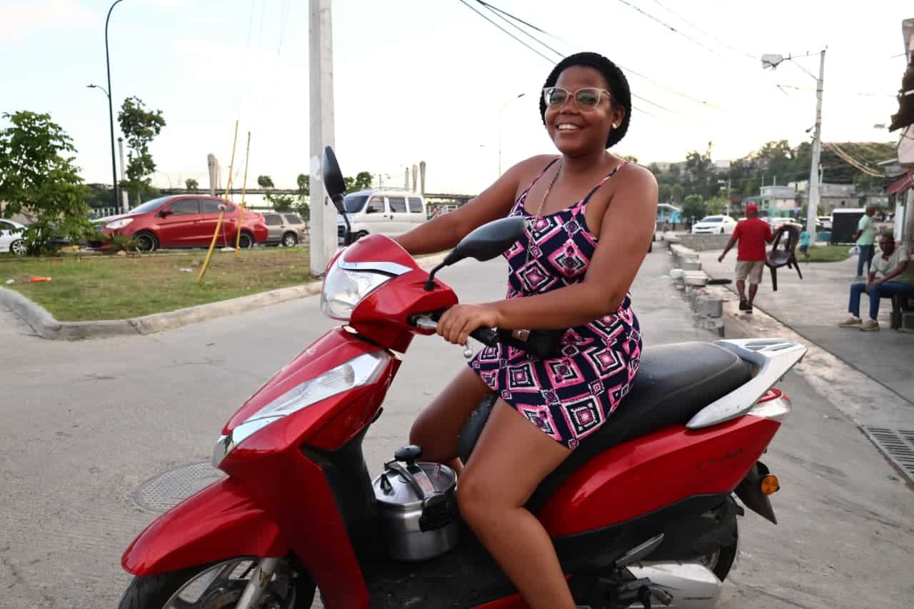 Una mujer se desplaza con una olla de presión en una pasola para elaborar su cena de Nochenuena.