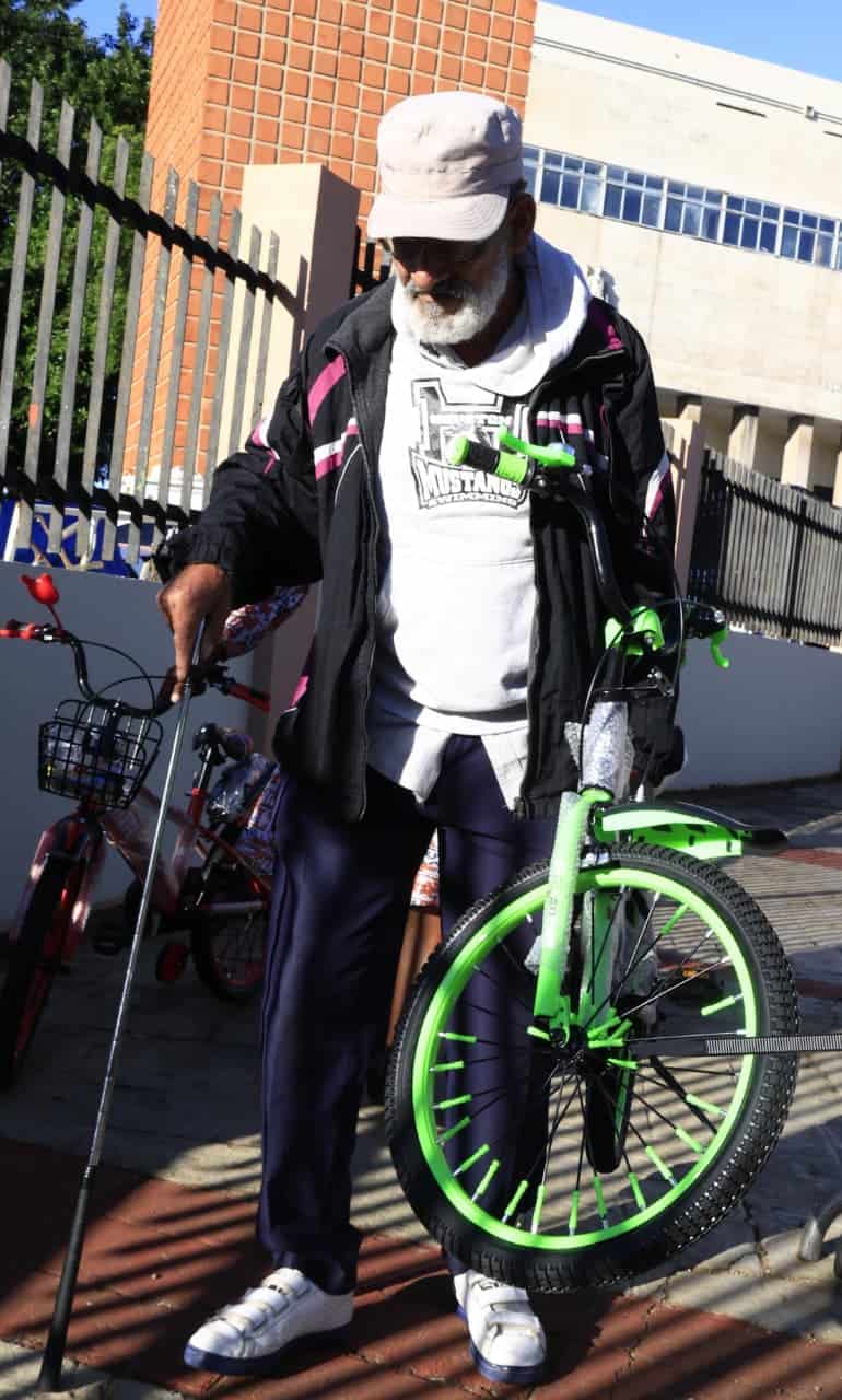 Pedro Antonio Estrella, un abuelo de 71 a&ntilde;os, sostiene sus manos una bicileta para su nieto.