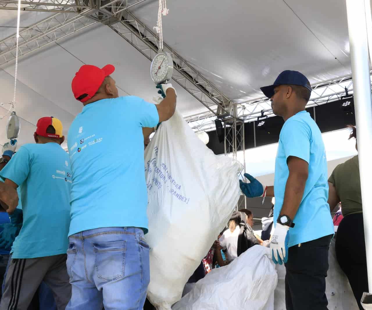 Personal de la Alcald&iacute;a del Distrito Nacional pesa las fundas con botellas pl&aacute;sticas. entregadas por los participantes del programa "Pl&aacute;sticos por Juguetes".