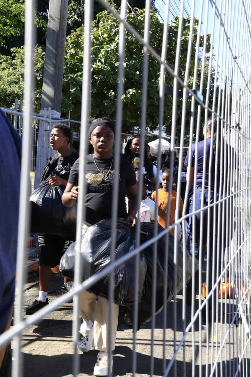 Familias esperan su turno en largas filas con bolsas y sacos llenos de botellas pl&aacute;sticas.