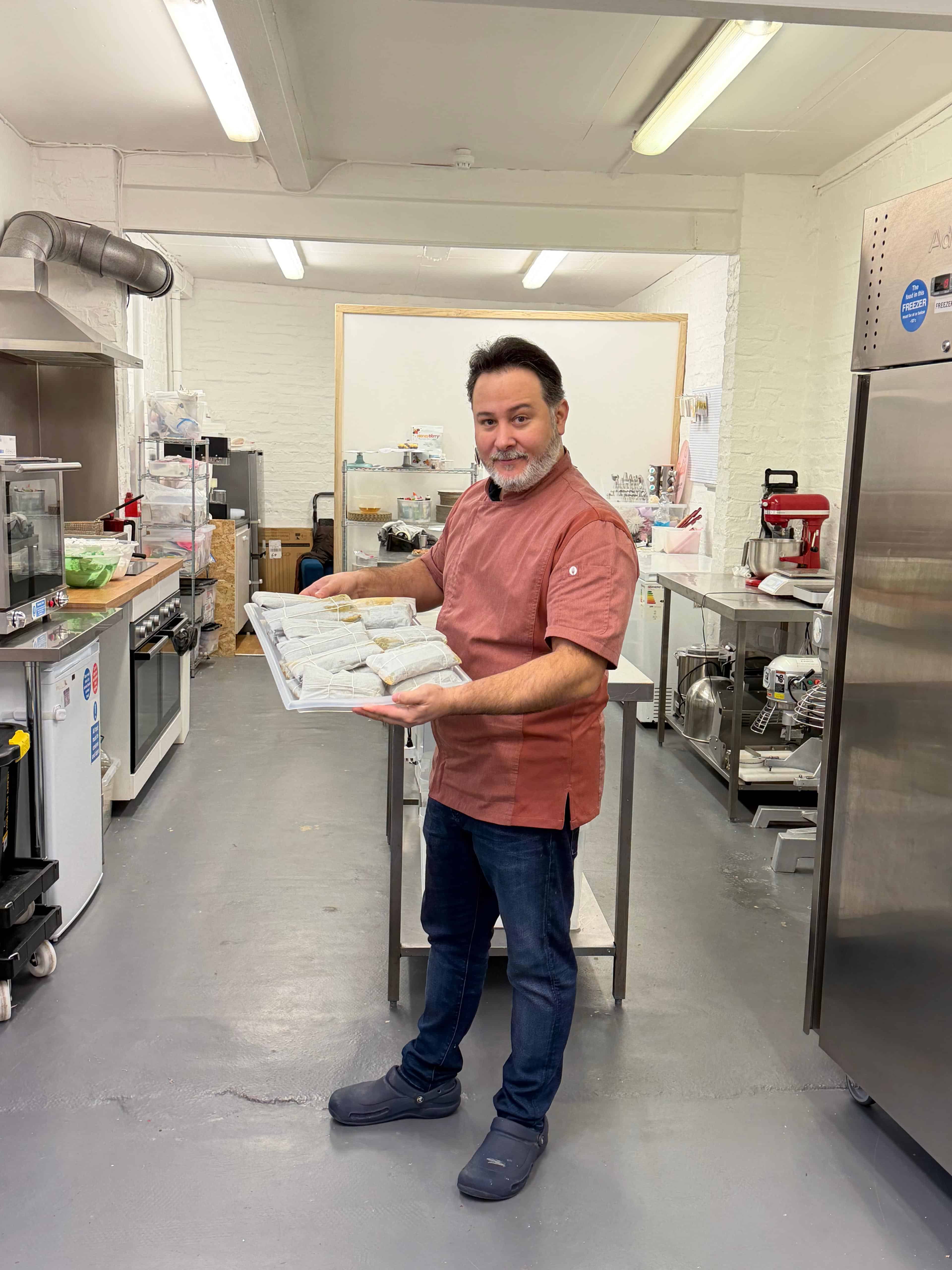 Jos&eacute; Casasnovas muestra una produci&oacute;n de pasateles en hoja de Kylie's Dominican Bakery.<br>