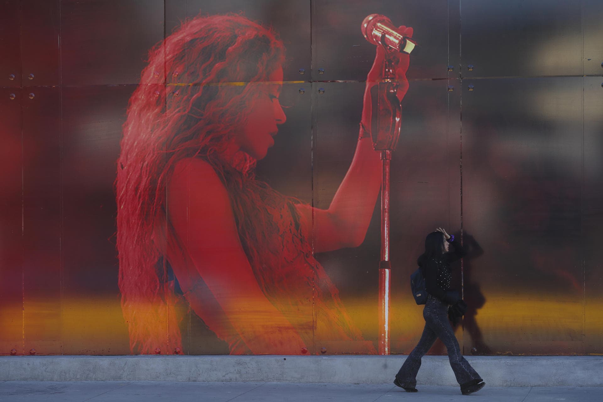 Una mujer camina frente a un aviso publicitario que anuncia el concierto de la cantante colombiana Shakira en el Estadio Jorge El M&aacute;gico Gonz&aacute;lez este jueves, en San Salvador (El Salvador).