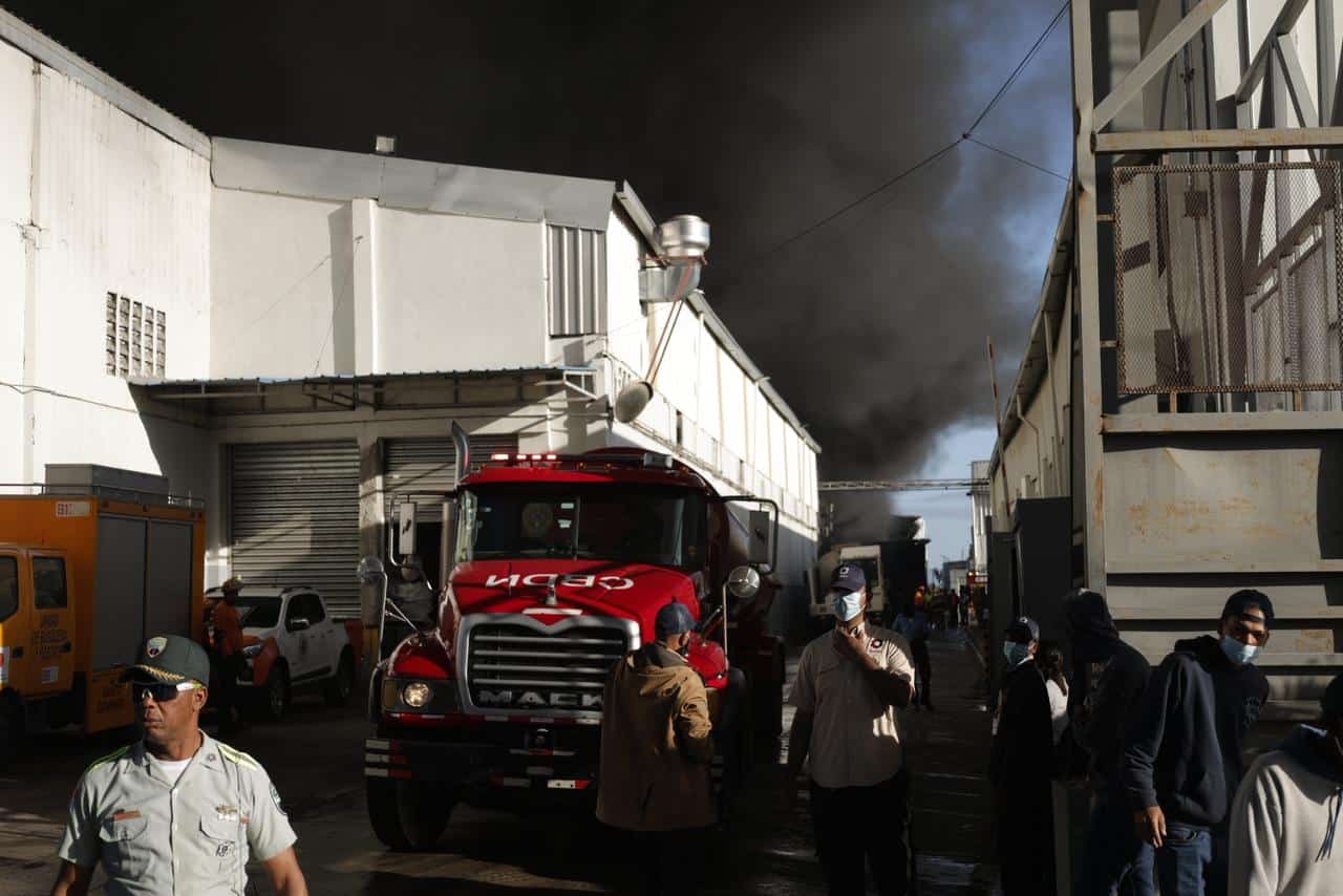 Camiones del Cuerpo de Bomberos trabajan en el control del incendio que afect&oacute; las instalaciones de la empresa Katae en Haina.