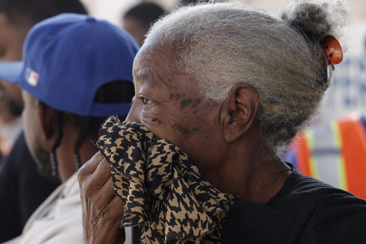 Una residente del sector Magdalena se cubre la nariz con un pa&ntilde;o ante la intensidad del humo que se expandi&oacute; por la comunidad tras el incendio en una empresa de Haina.