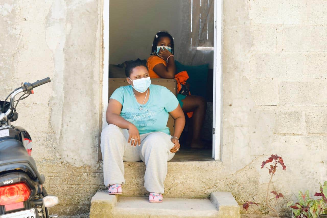 Cindy Maldonado permanece sentada en la entrada de su vivienda con mascarilla, luego de pasar la madrugada despierta por el humo generado por el incendio.