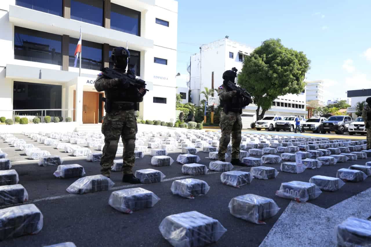 Miembros de la DNCD custodian los paquetes de presunta cocaína ocupados en la embarcación interceptada al sur de Baní.