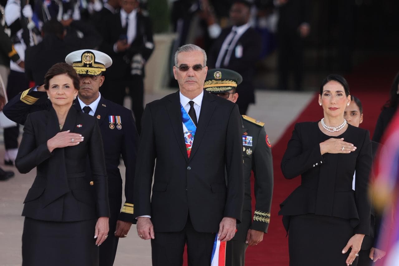 El presidente Luis Abinader durante la entonaci&oacute;n del Himno Nacional a su llegada al Congreso, acompa&ntilde;ado por la primera dama Raquel Arbaje (derecha) y la vicepresidenta Raquel Pe&ntilde;a (izq.).