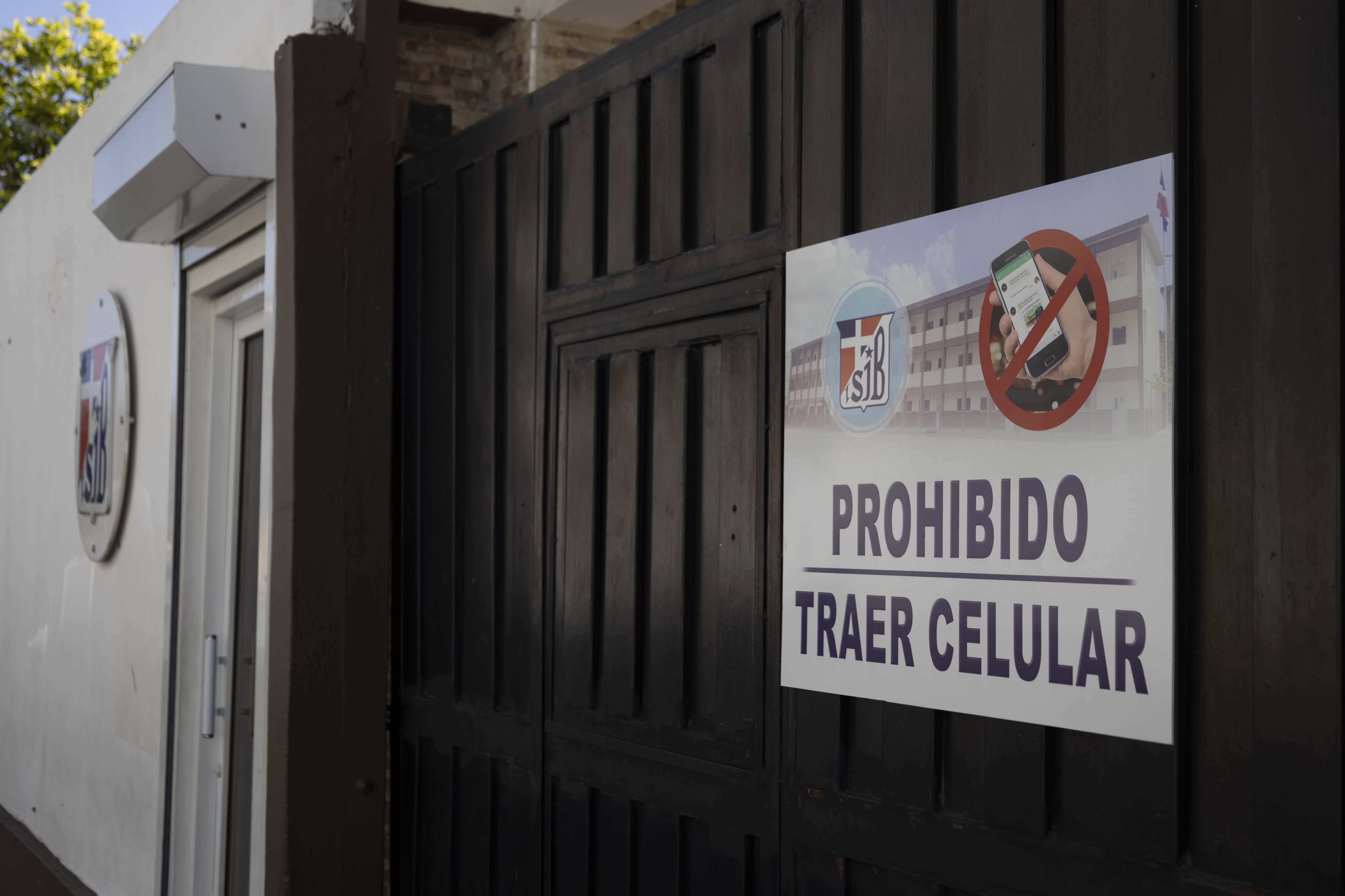 Un cartel en la entrada del Instituto San Juan Bautista recuerda a los estudiantes la prohibición de llevar celulares al plantel.