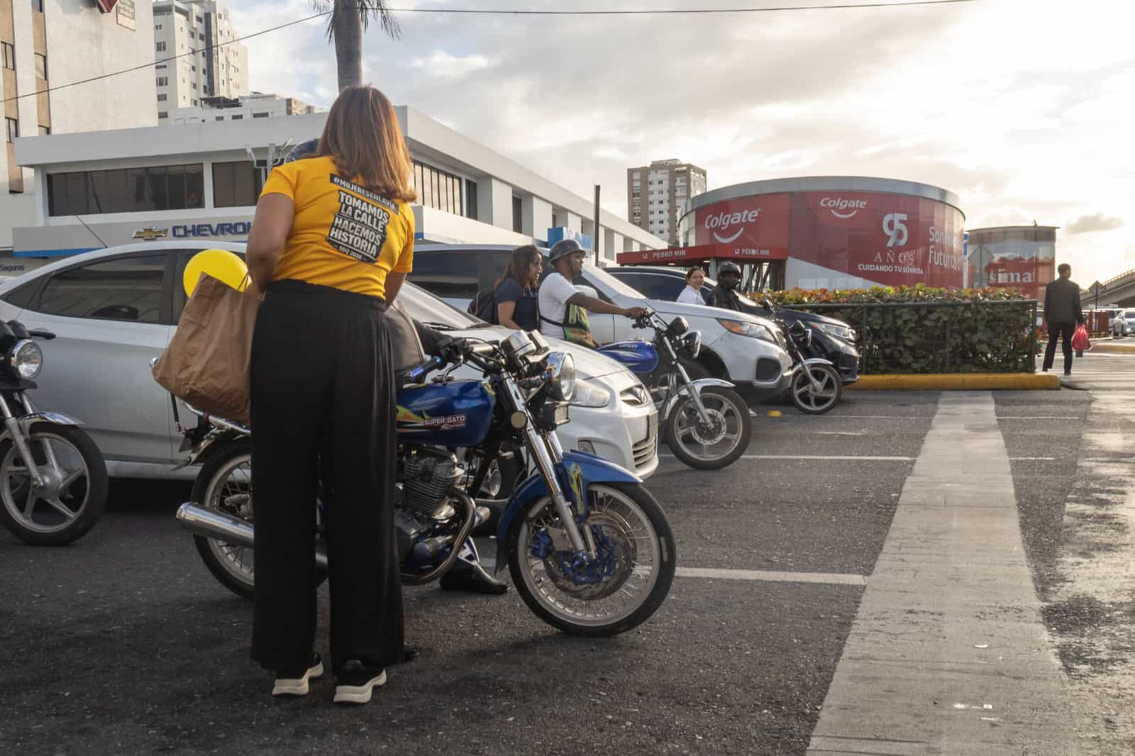 Una de las activistas entrega materiales a un conductor de motocicleta.