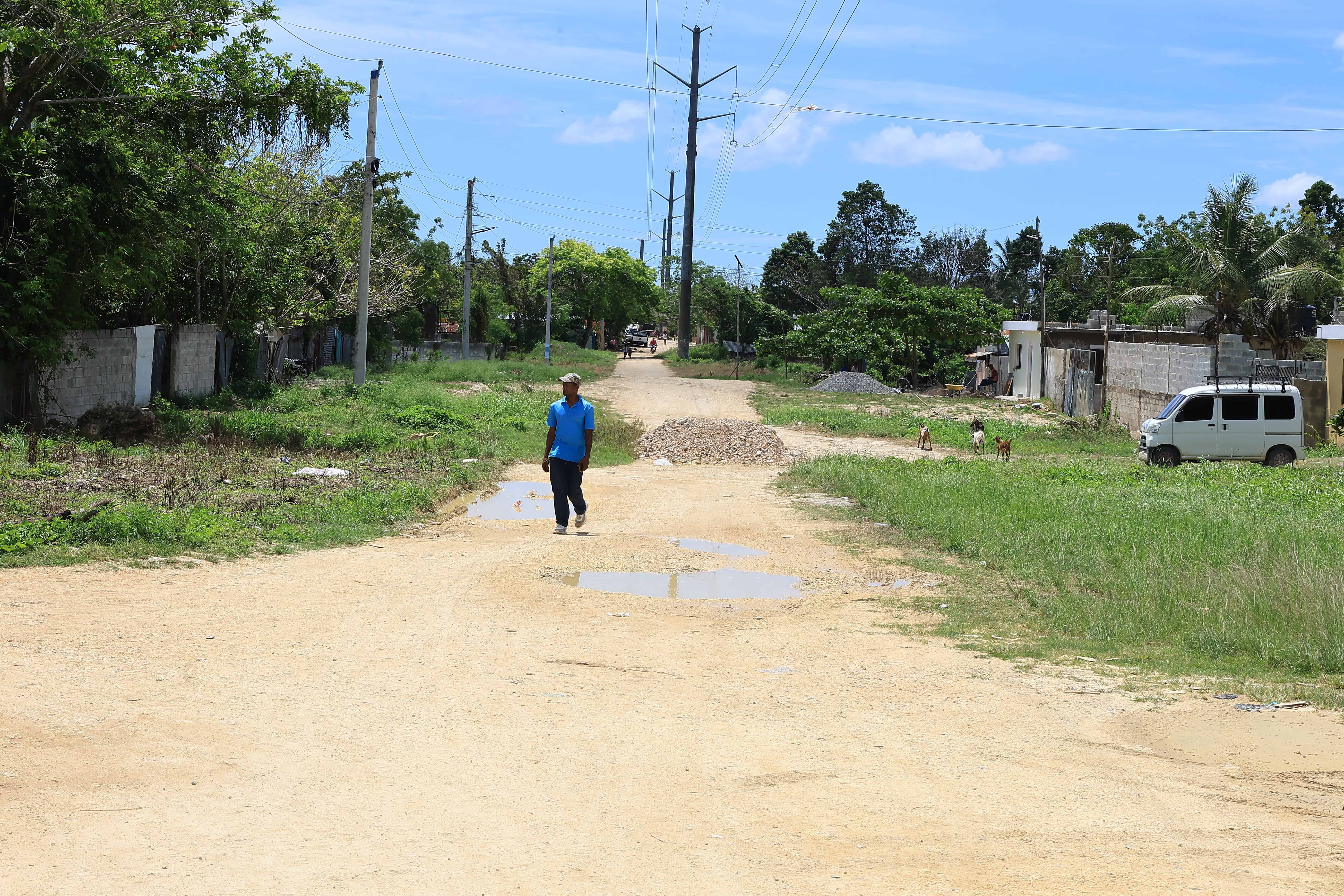 Un hombre camina por una calle sin asfaltar en Brisas del Norte de Boca Chica.