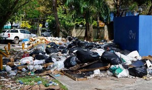 Cúmulo de basura y vehículos abandonados en el recinto del estadio Quisqueya
