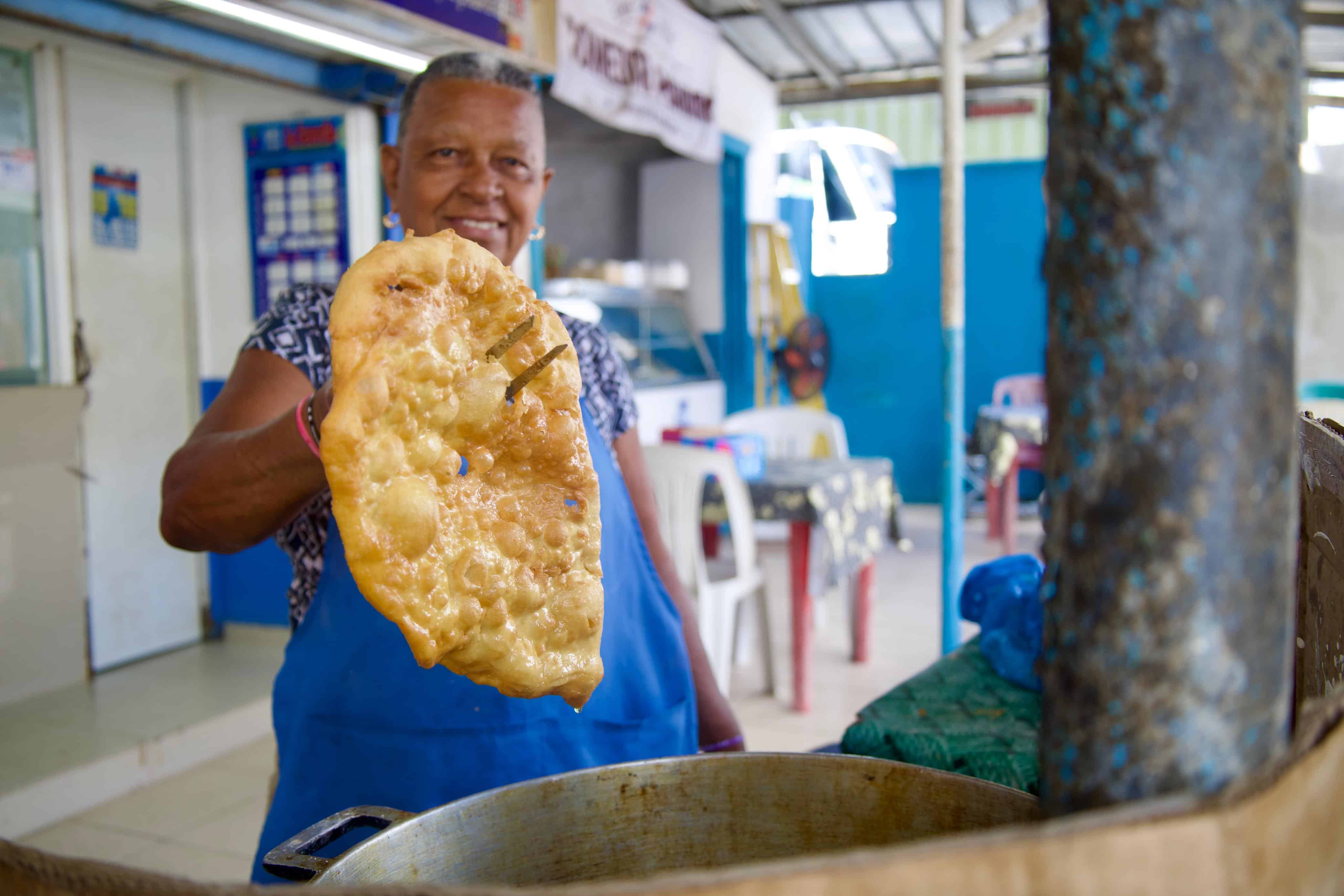 Vendedora prepara yaniqueques para los visitantes que recorren la playa.