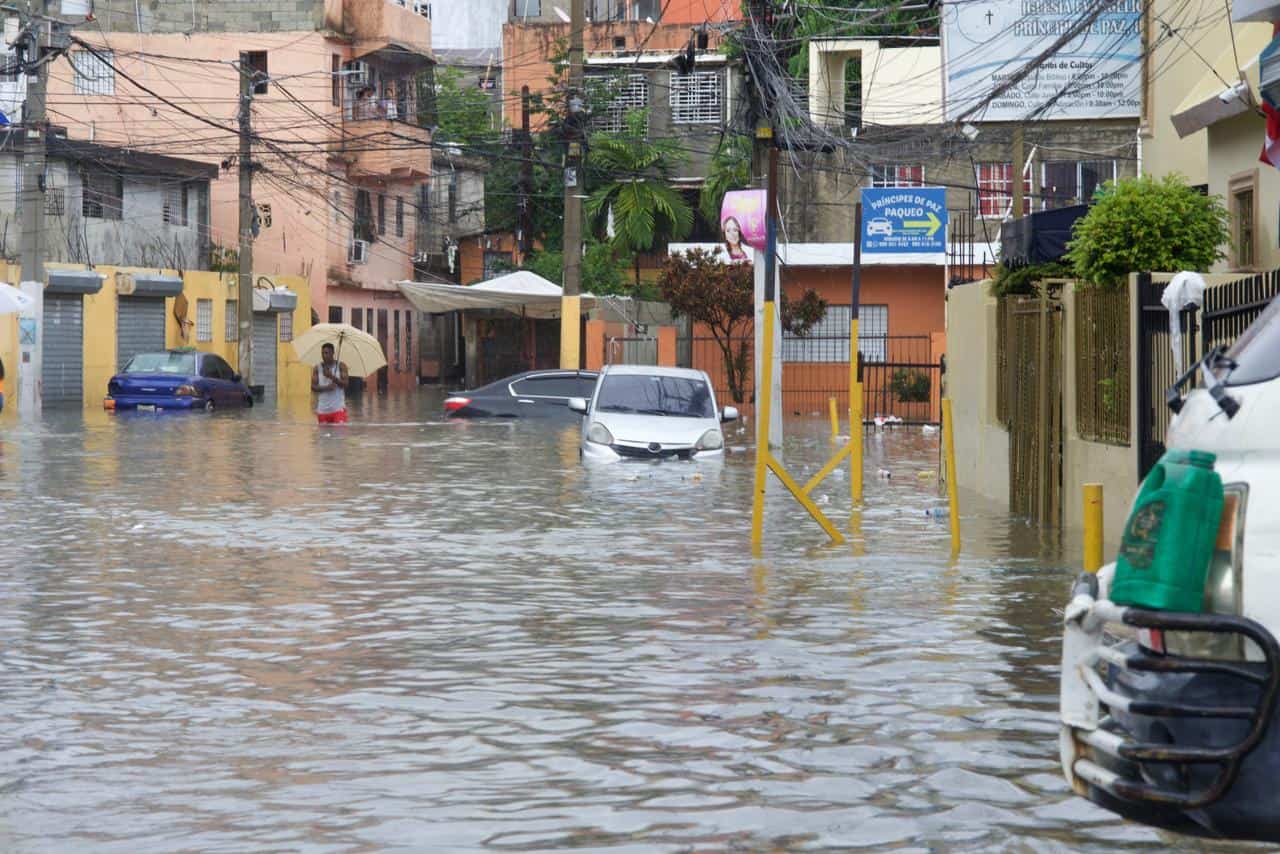 Vehículos quedaron bajo el agua tras las fuertes lluvias en el Ensanche Quisqueya.