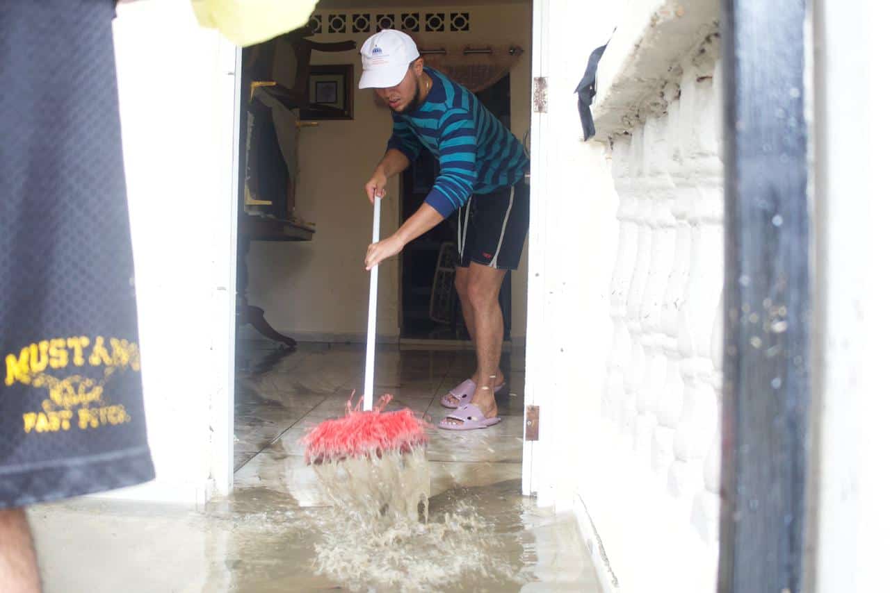 Con escobas y cubetas, afectados sacan el agua de sus viviendas.