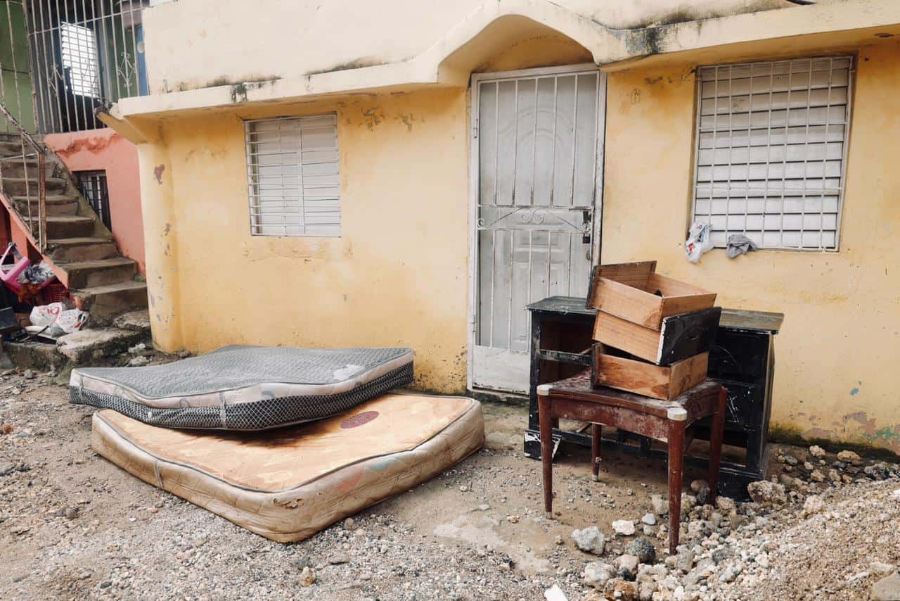 Familia pone a secar colchones afectados por las lluvias.