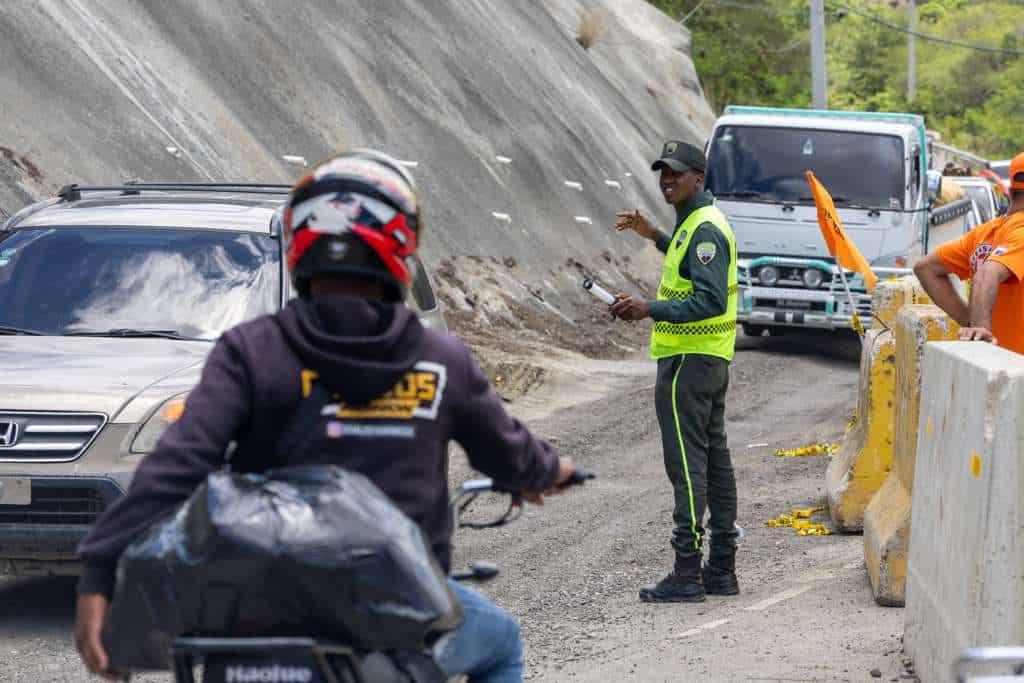 Un agente de la Digesett moviliza el tránsito en la carretera Ocoa–Cruce de Ocoa, tras el socavón.
