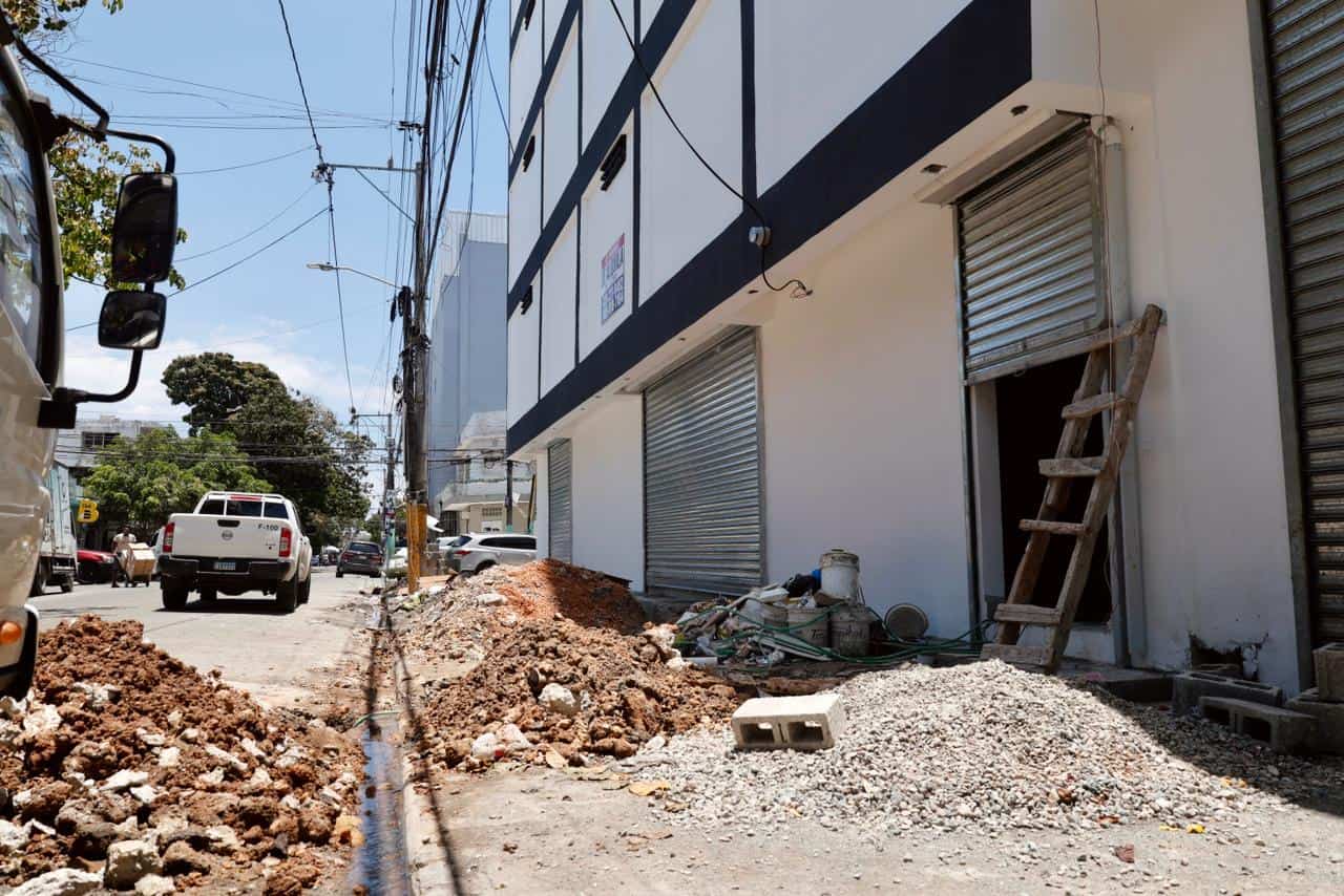 Arena, block y otros residuos en las aceras de un negocio en la calle Juan Saltitopa esquina Eusebio Manzueta.