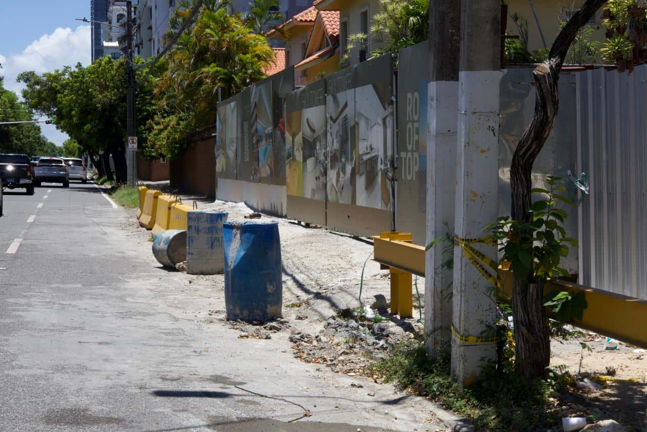 Tanque, muros tipo jersey y cemento adherido en la acera por la avenida Anacaona.