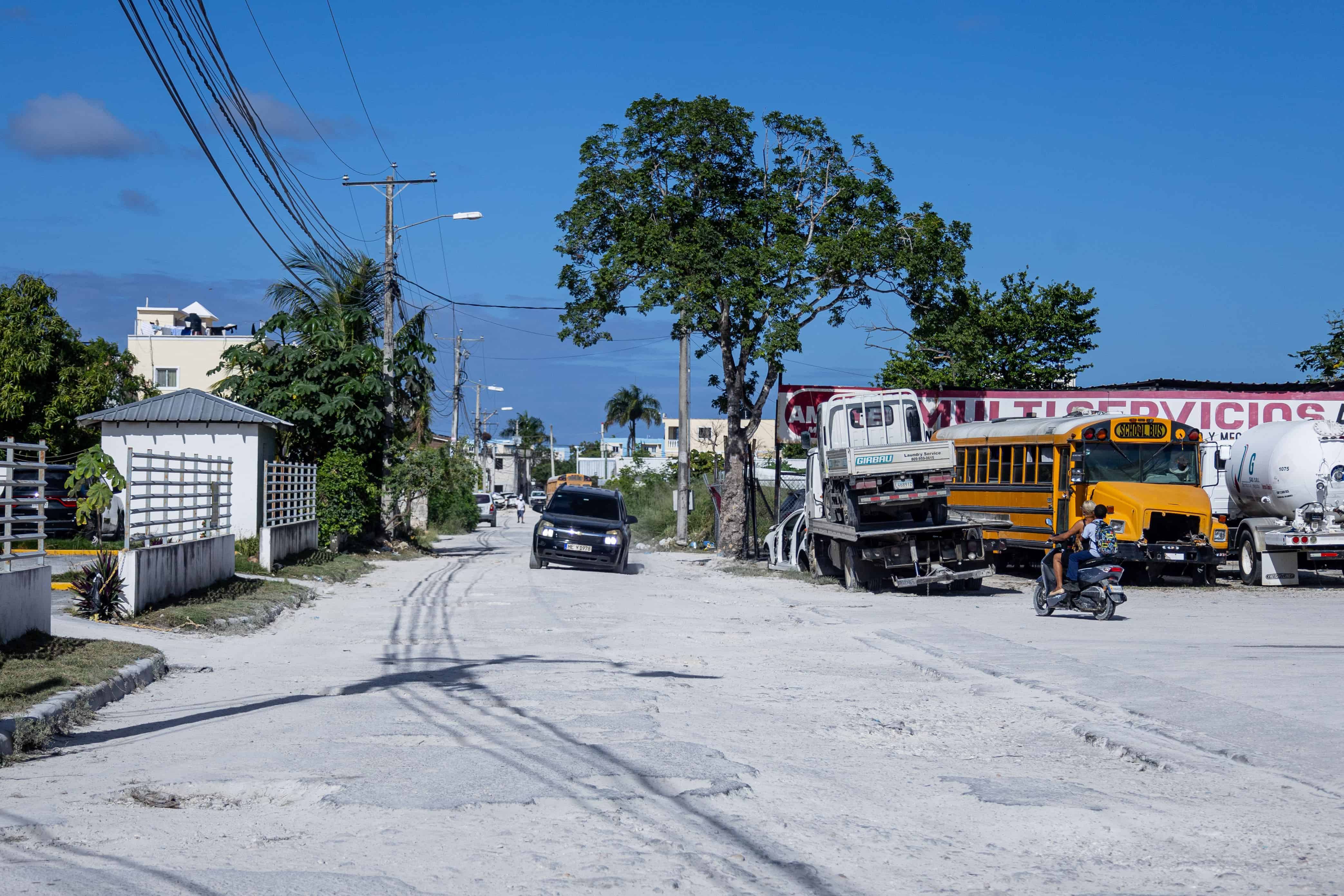 Un veh&iacute;culo saliendo por una calle sin asfaltar en la zona urbana de Ver&oacute;n-Punta Cana.