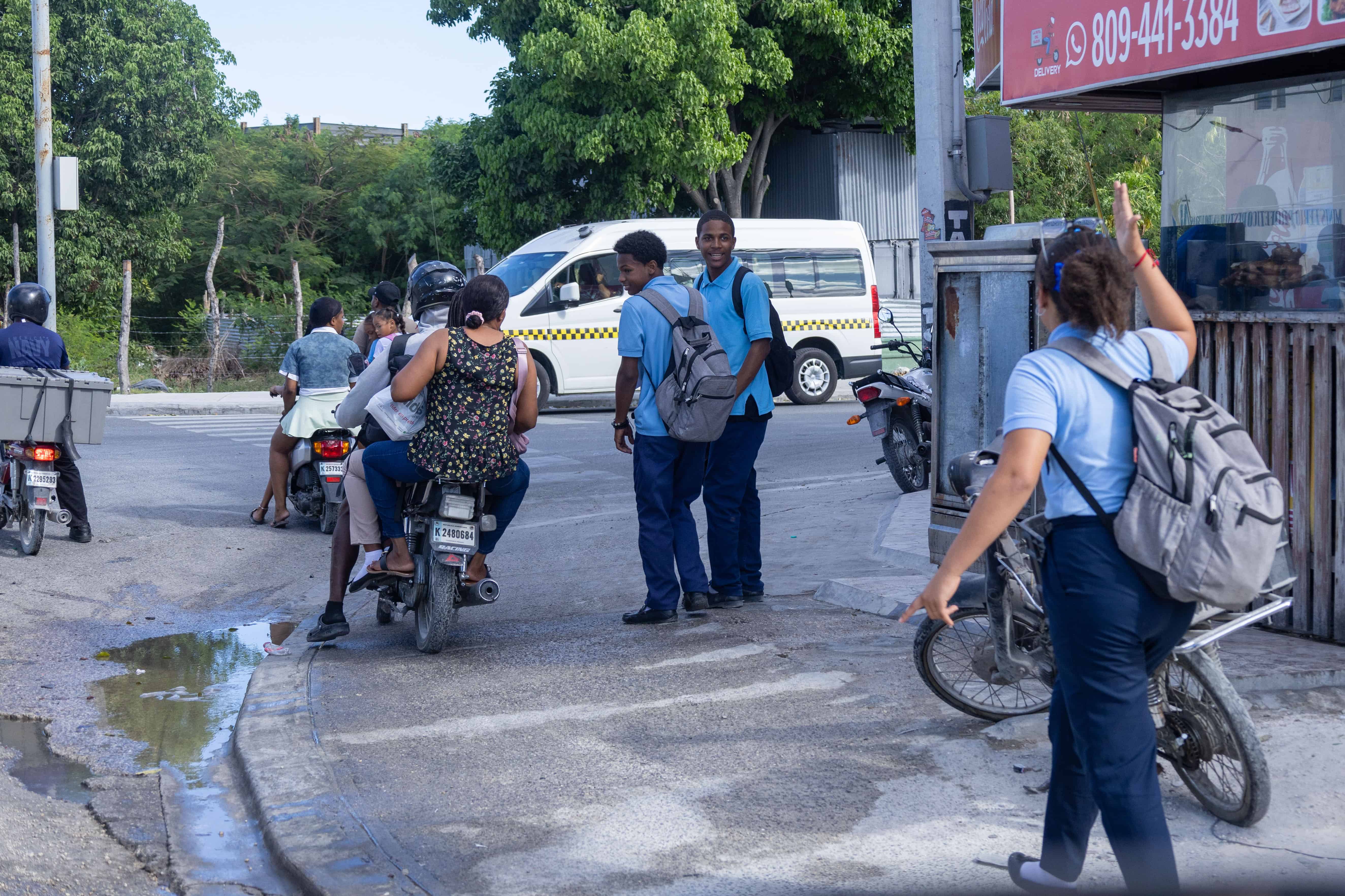 La joven estudiante llamando a sus compa&ntilde;eros al avistar a los motoristas que se subieron a la acera.