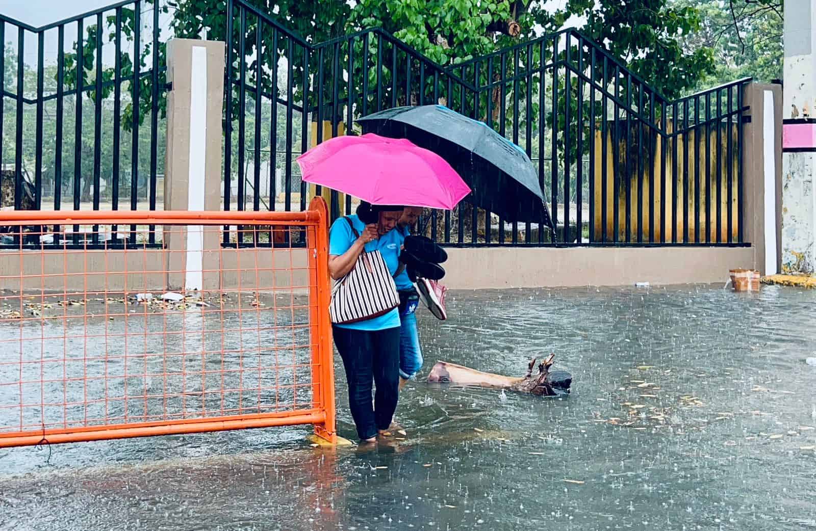 Ciudadanos presentan dificultad al usar aceras debido a las inundaciones provocadas por la lluvia.