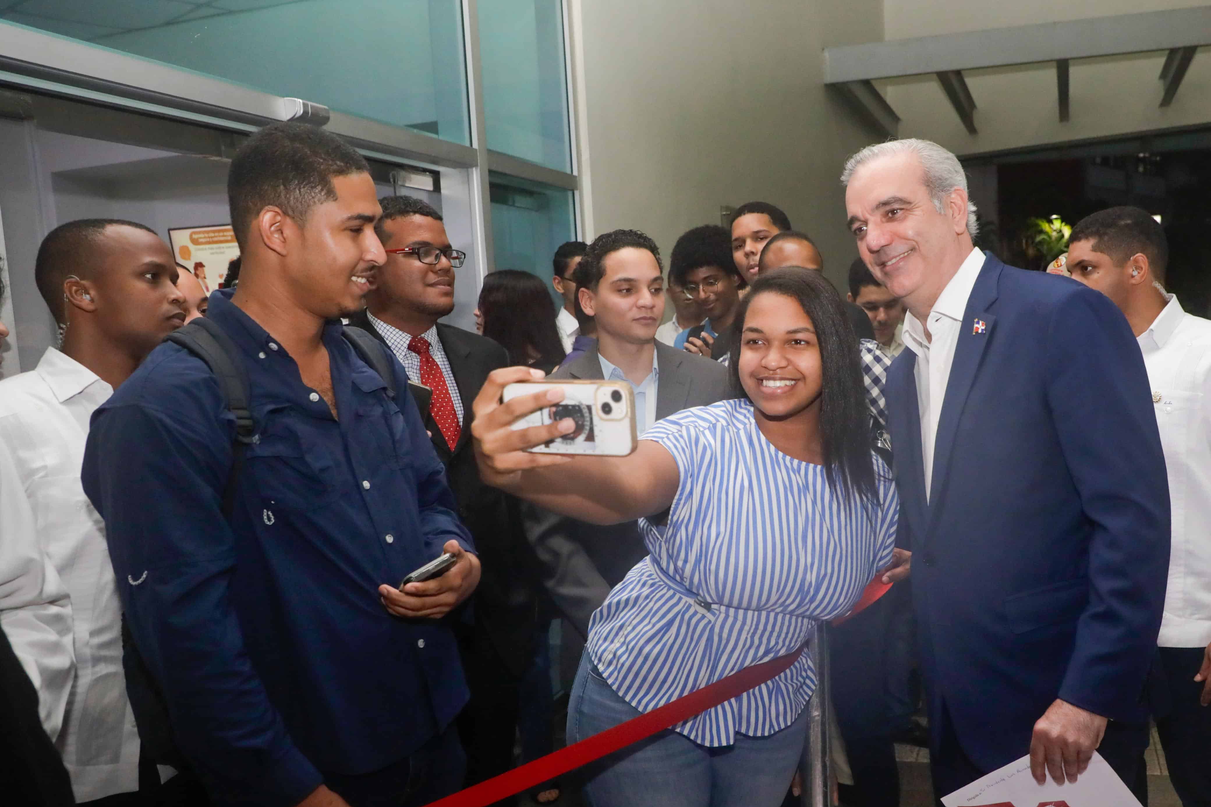 Una joven se toma una selfie junto al presidente Luis Abinader en Intec.
