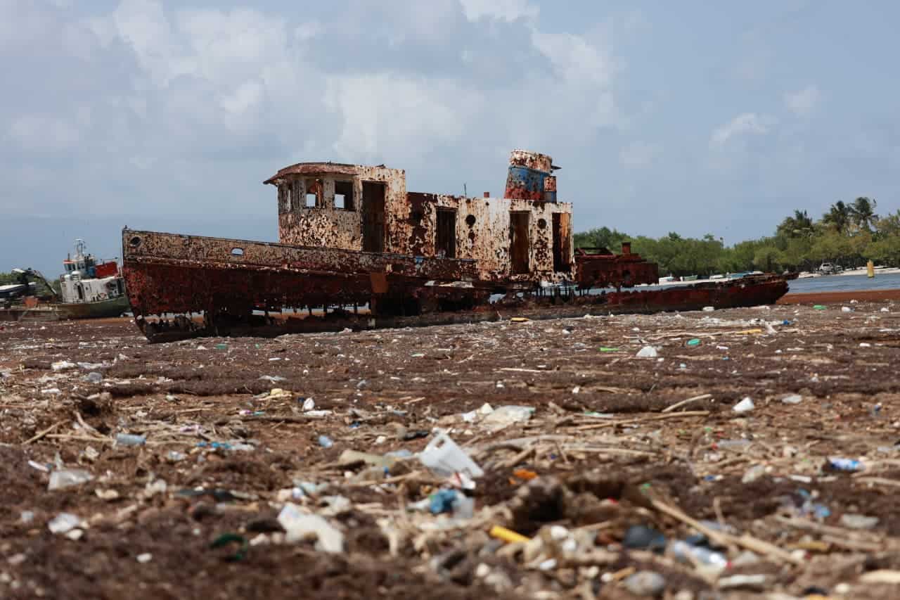 Un barco encallado permanece sobre una playa cubierta de sargazo y residuos plásticos en Barahona, el 29 de mayo de 2026.