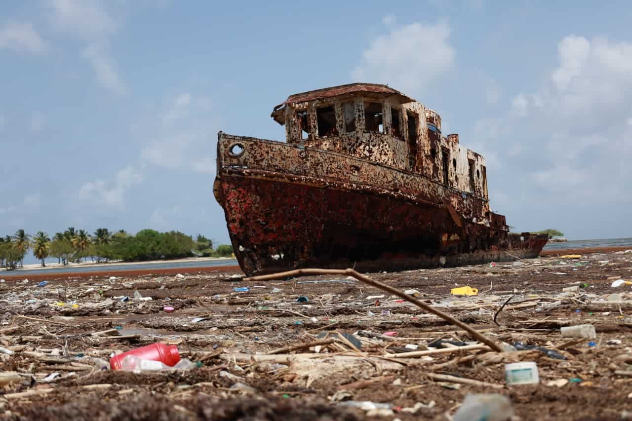 Un barco encallado permanece sobre una playa cubierta de sargazo y residuos plásticos en Barahona, el 29 de mayo de 2026.