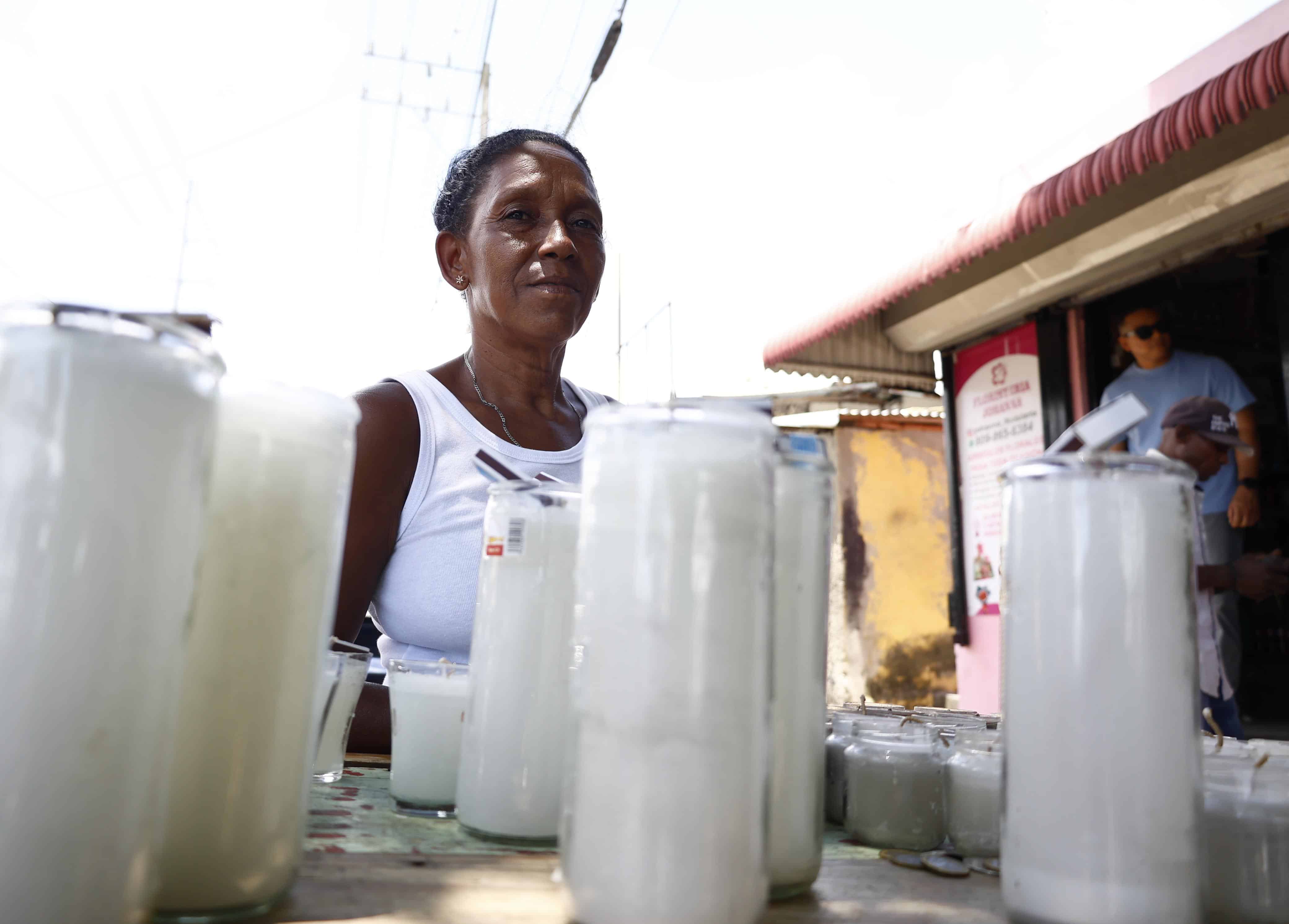 Una comerciante ofrece velones en las afueras del cementerio Cristo Rey durante la celebración del Día de las Madres.