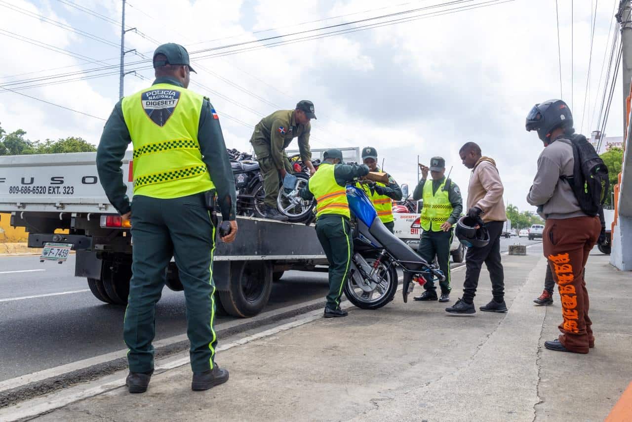 Agentes de la Digesett cargan una motocicleta retenida durante un operativo realizado en la avenida John F. Kennedy, en el Distrito Nacional.