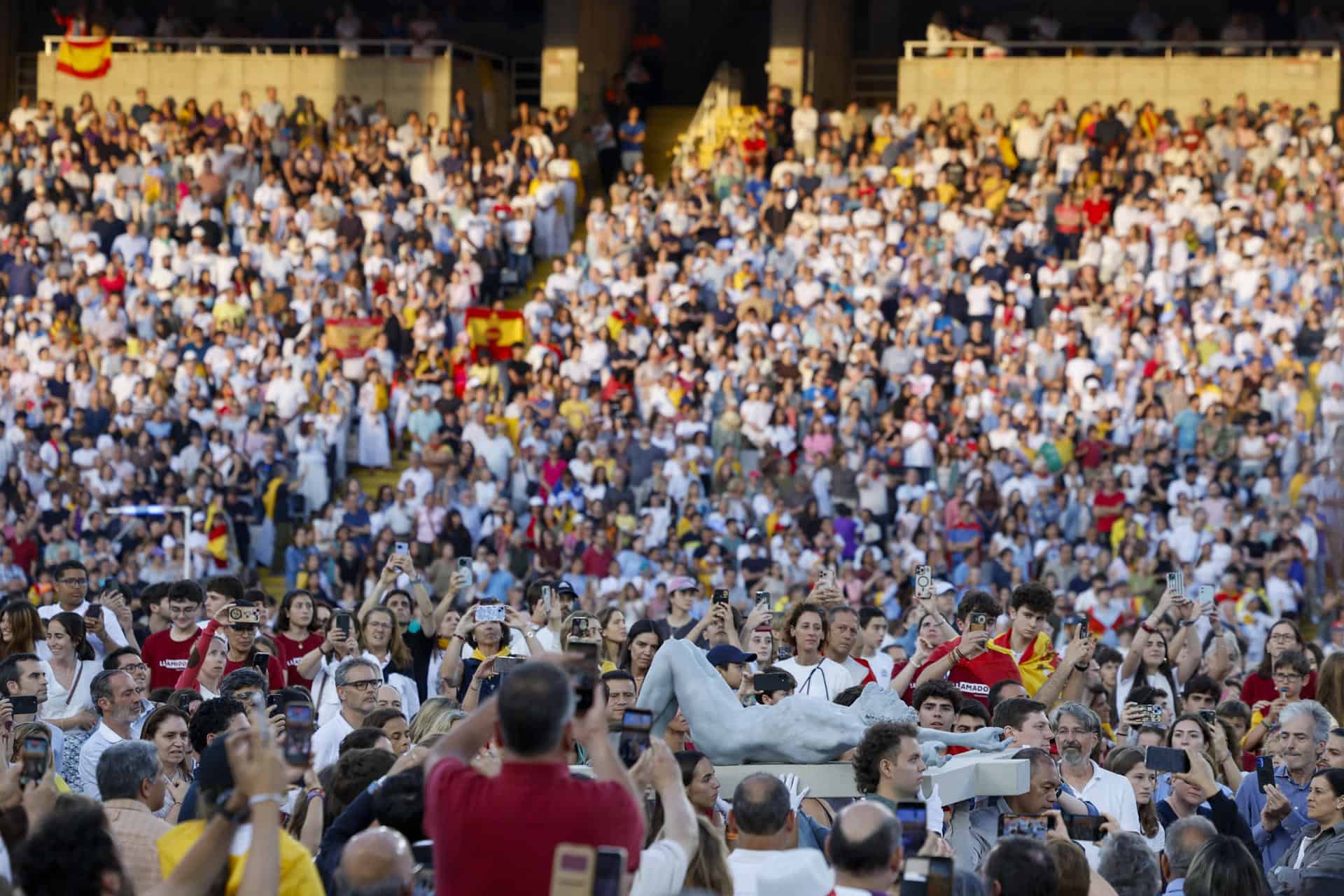 Varios j&oacute;venes portan una cruz durante la vigilia que celebra el papa Le&oacute;n XIV con 40.000 personas este martes en el Estadio Ol&iacute;mpico de Barcelona. 