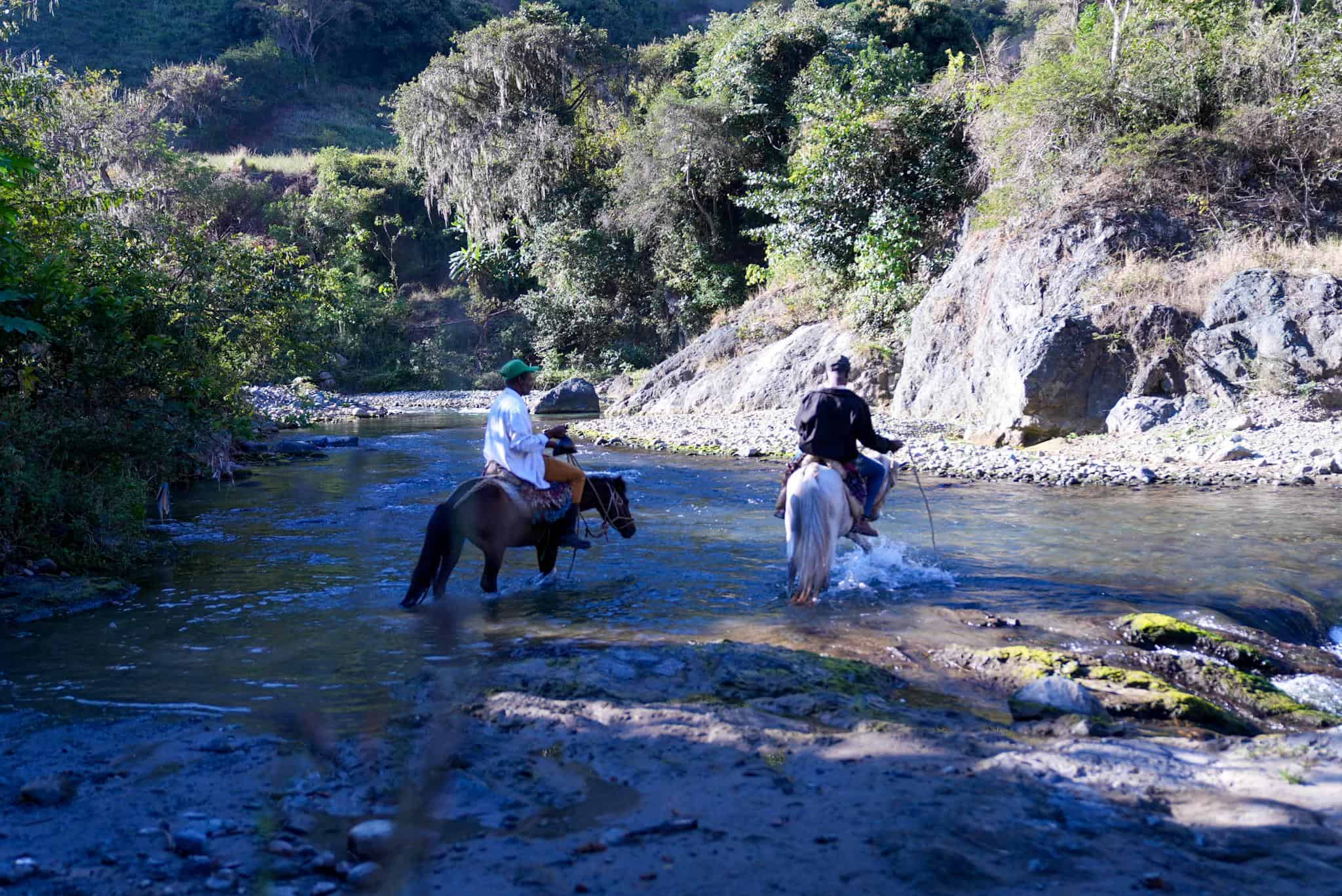 Dos comunitarios mientras cruzan el río al Medio. 