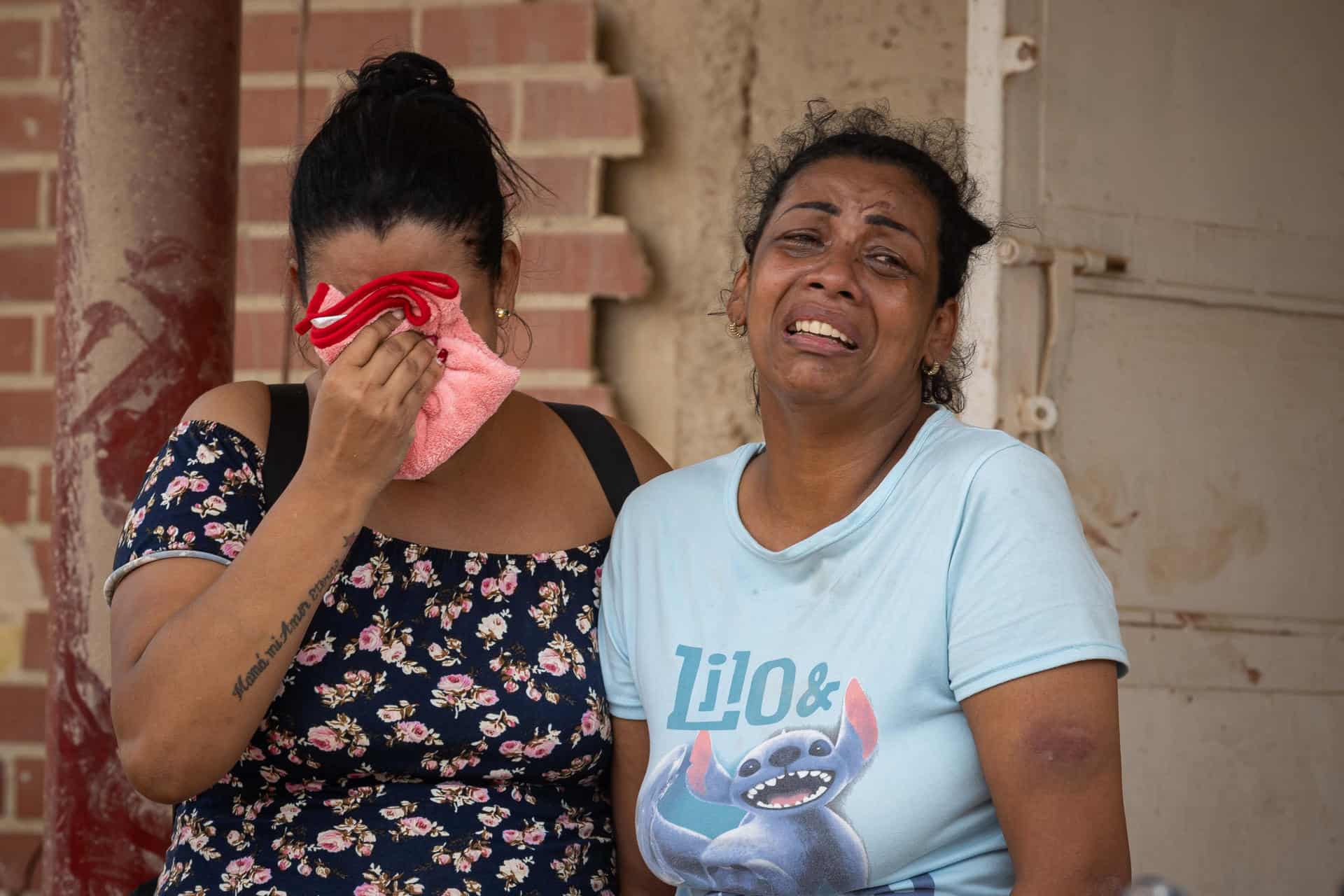 Personas lloran al observar escombros de edificios derrumbados por terremotos este jueves, en La Guaira (Venezuela).