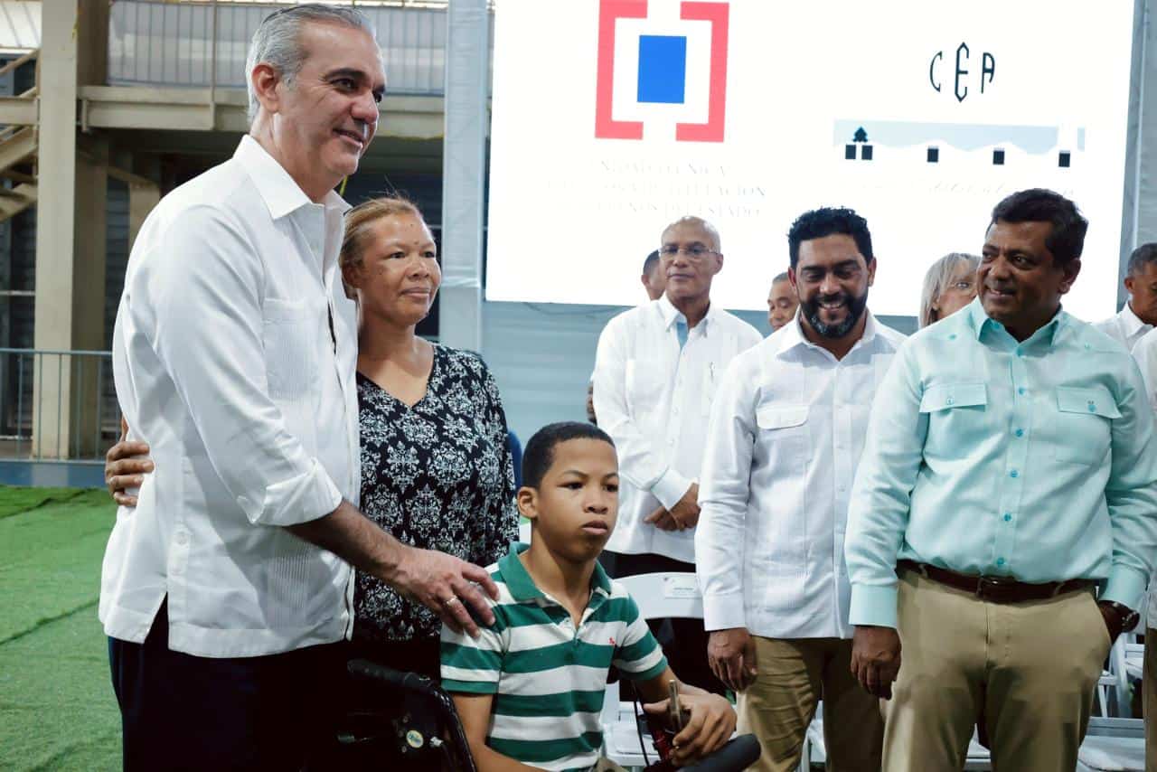 El presidente Abinader saluda a una beneficiaria.
