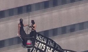 Dos personas suben a la cima del Empire State Building con una pancarta a favor de la paz