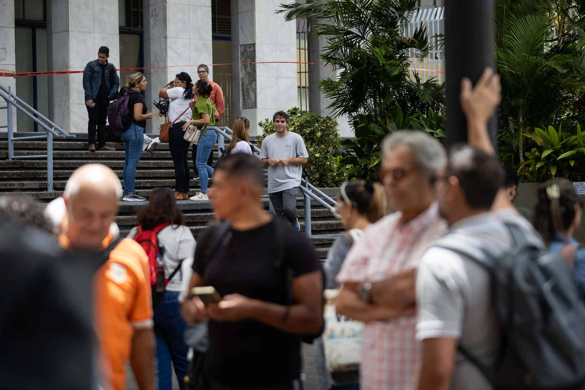Personas esperan en una calle este viernes, luego de un temblor de magnitud 3.9, en Caracas (Venezuela). 