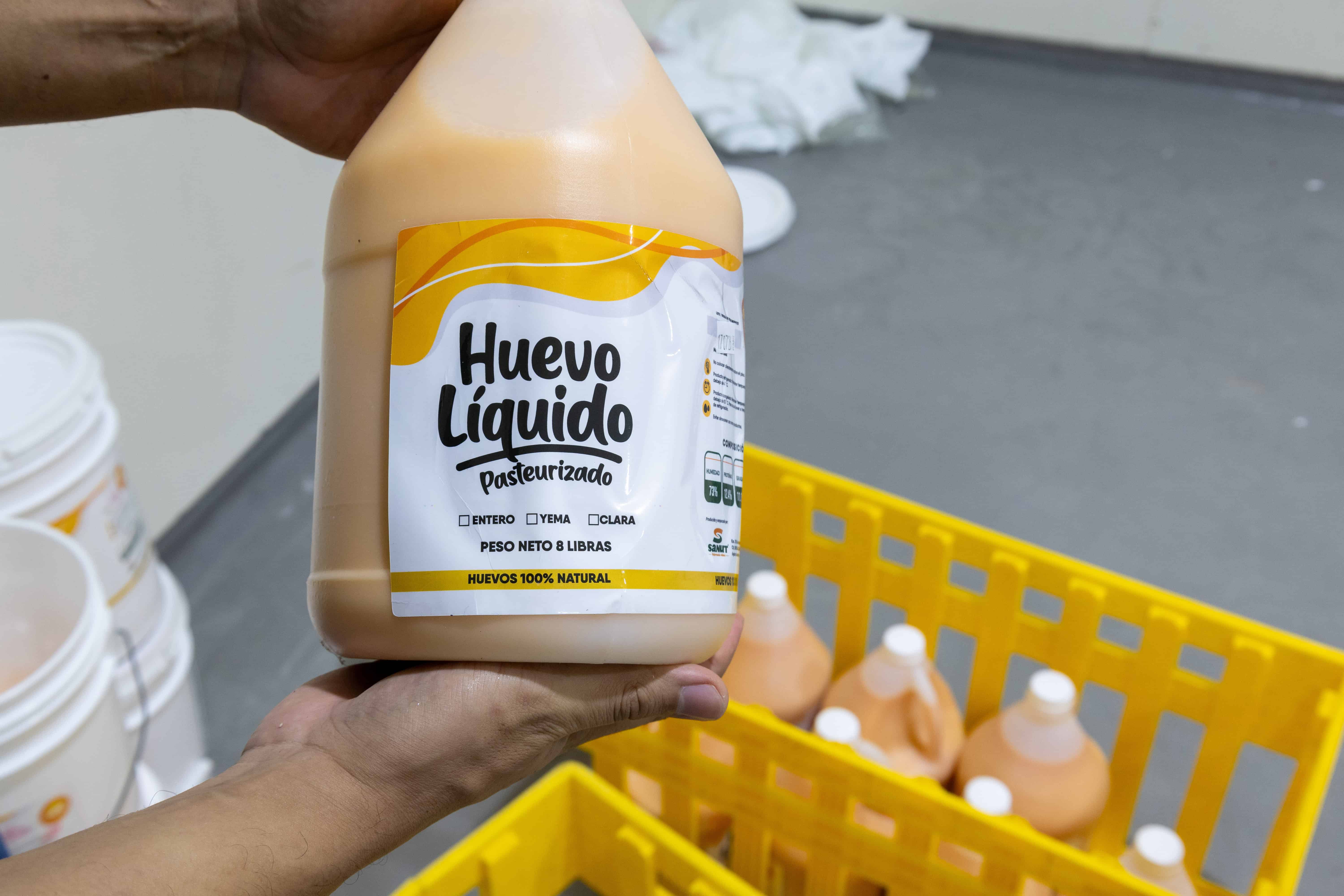Miguel Lajara sostiene un galón de huevo líquido, una de las presentaciones disponibles en las cuales se comercializa el producto.