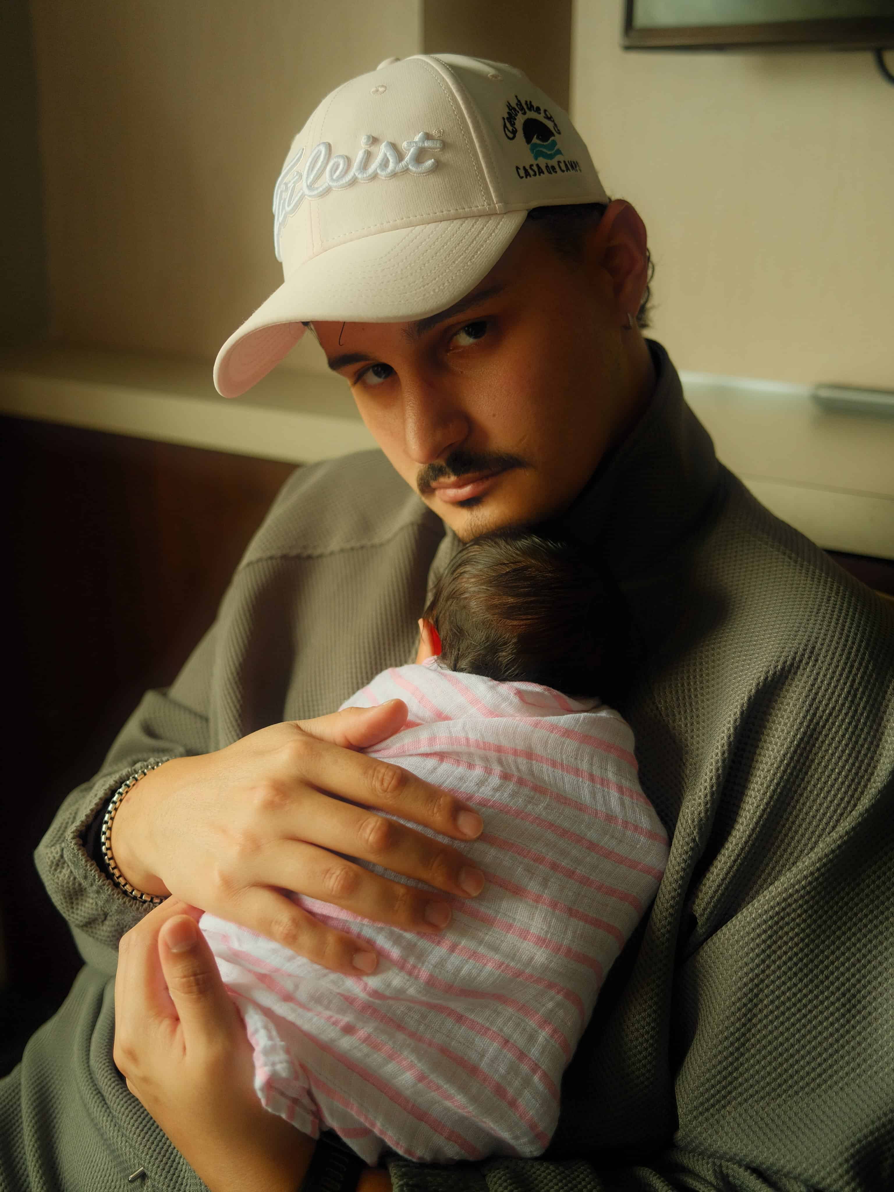 Carlos Olmos, el esposo de la influencer, sosteniendo a su beb&eacute;.
