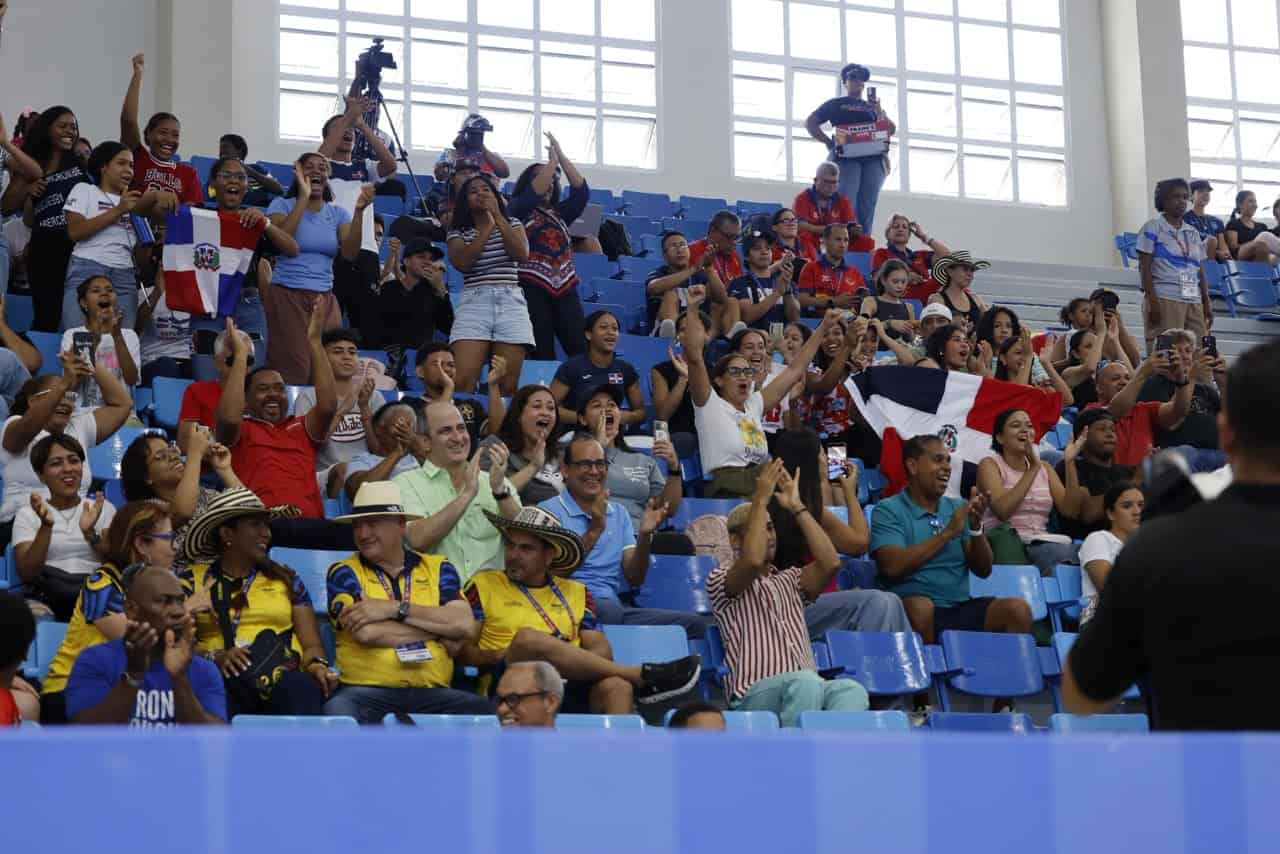 Seguidores de la delegación dominicana celebran y apoyan a los gimnastas durante su presentación en la competencia.