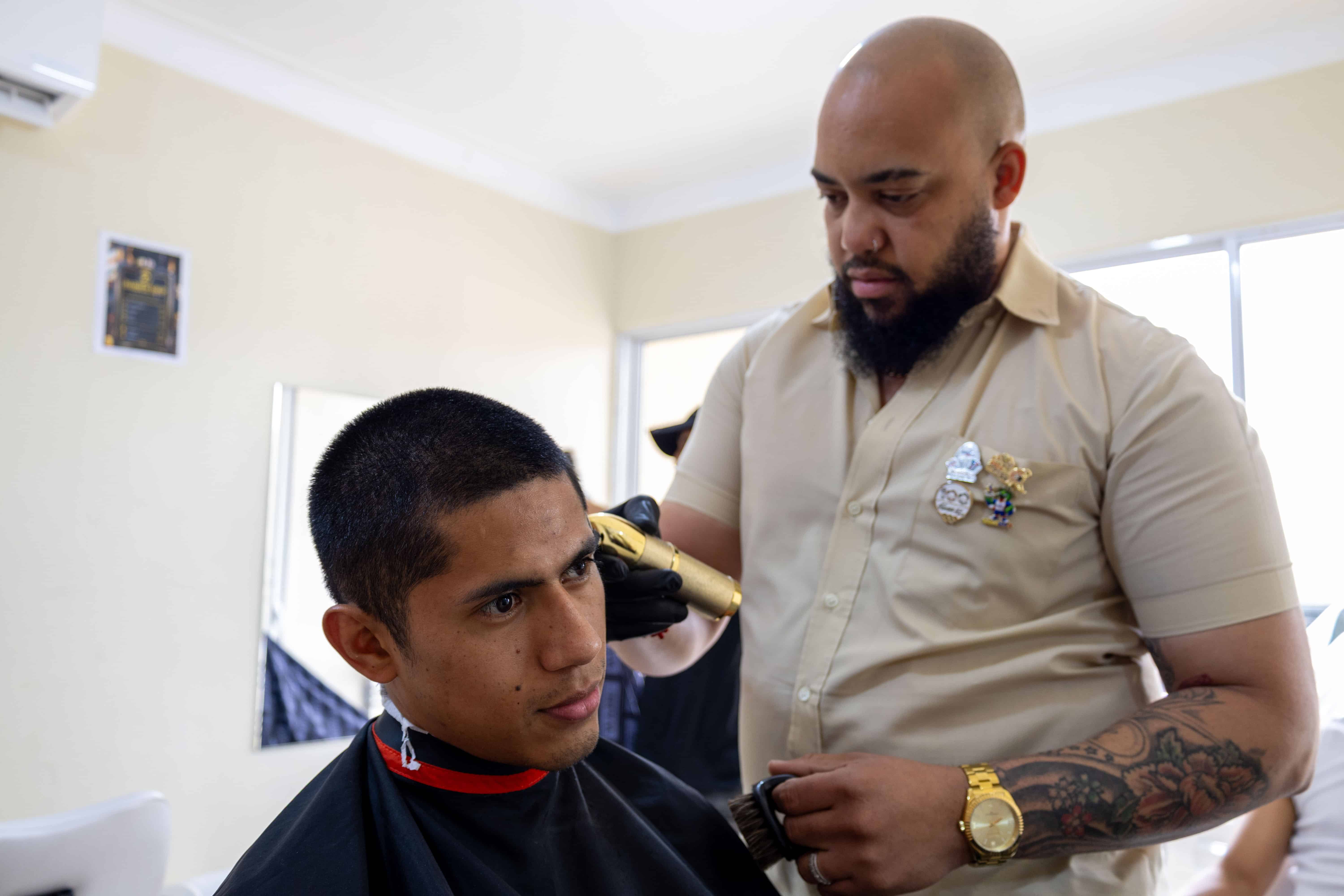 Un atleta mexicano recibiendo servicio en la barber&iacute;a