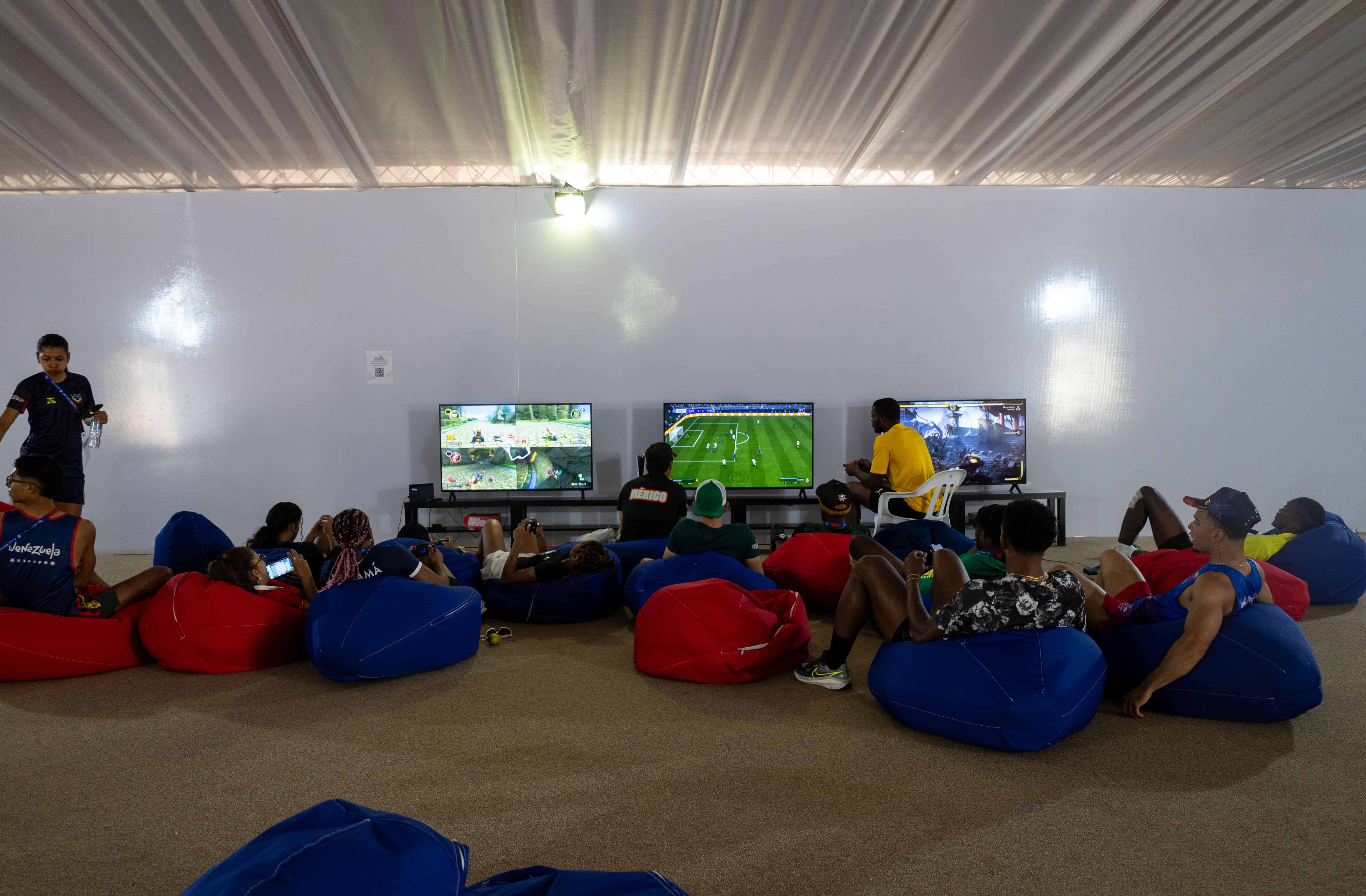 Atletas de distintas partes reunidos en la carpa de entretenimiento