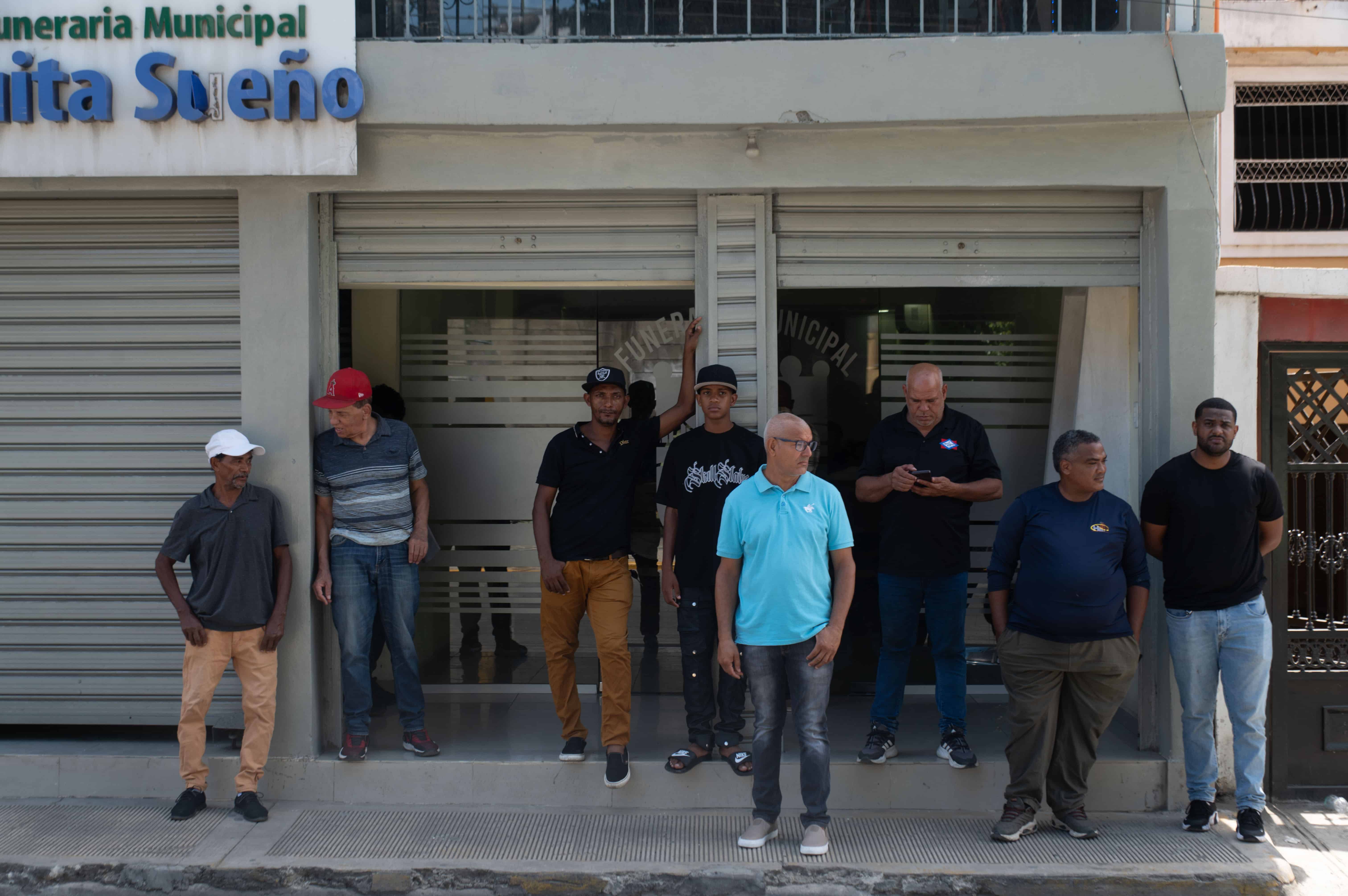 Familiares, vecinos y allegados permanecieron frente a la funeraria municipal de Quita Sueño, en Haina, a la espera de la llegada de los cuerpos de las víctimas de la explosión.