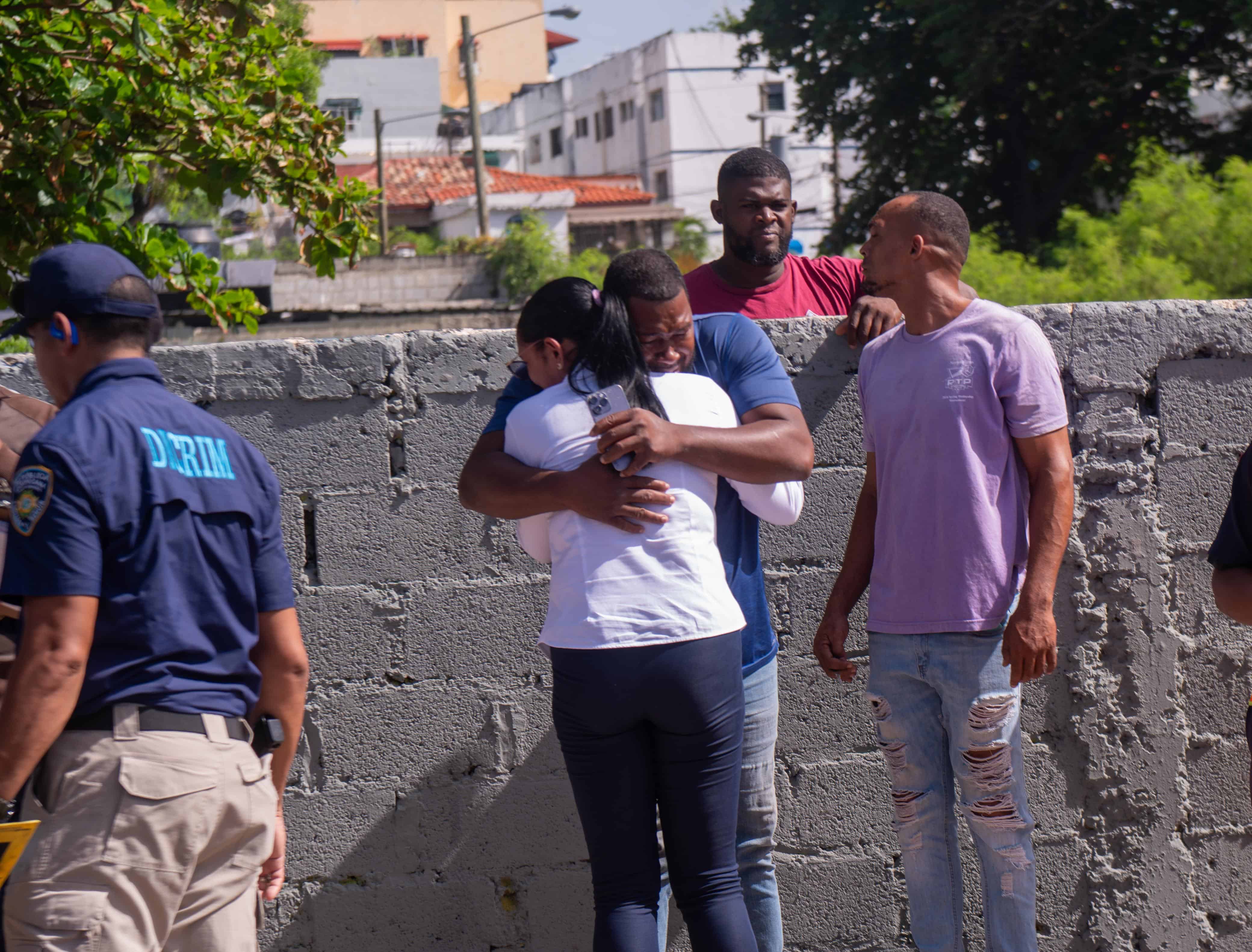 Dos personas se abrazan y lloran en las inmediaciones donde ocurrió el accidente que dejó dos personas fallecidas.