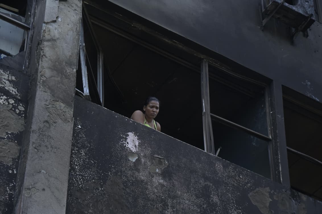 Una mujer observa desde uno de los apartamentos afectados los daños provocados por el incendio en el edificio Dr. Luis Franco.