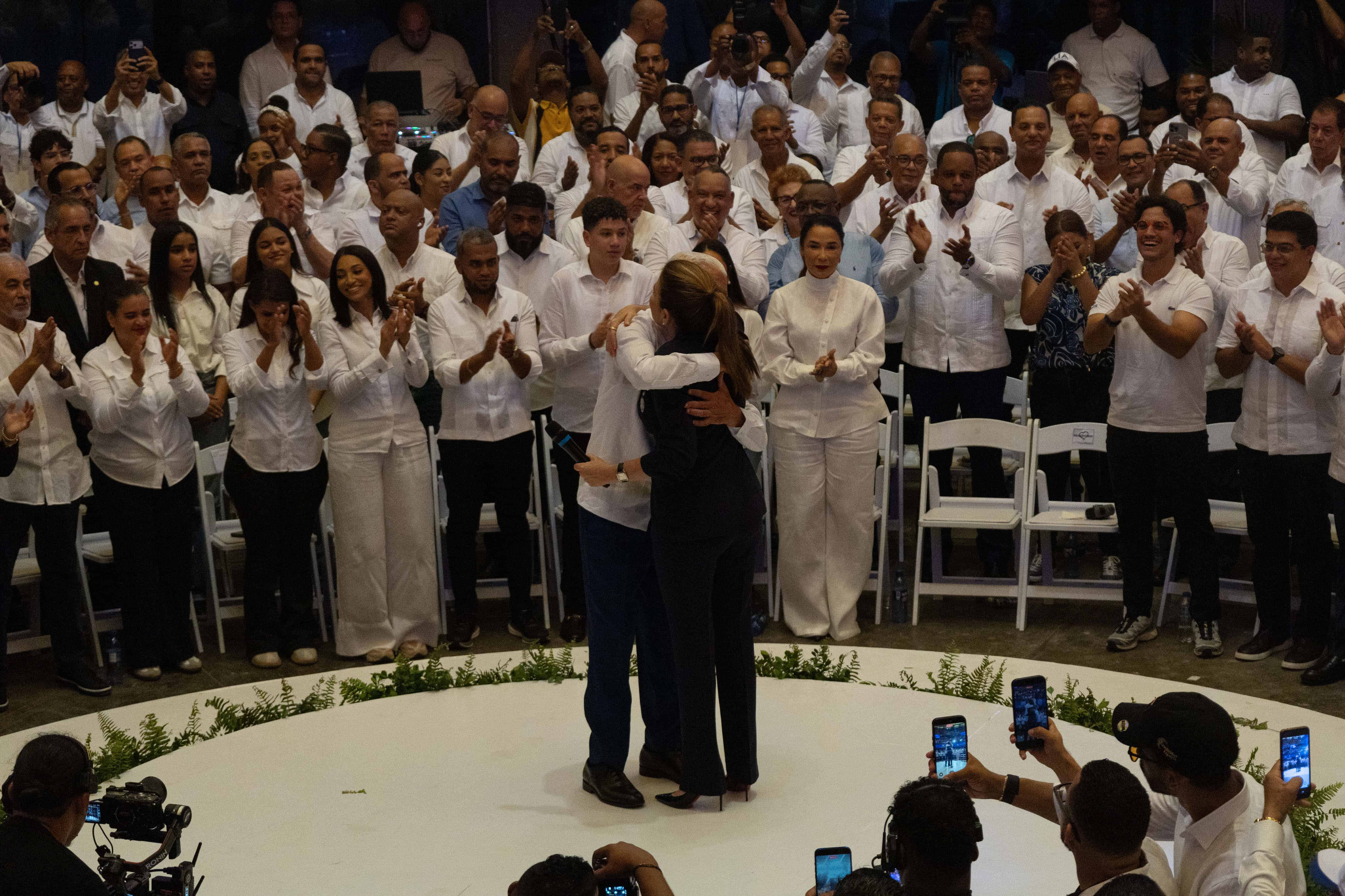 Carolina Mejía y Ricardo de los Santos se abrazan durante el acto en el que el presidente del Senado fue juramentado como coordinador nacional de campaña de la aspirante presidencial del PRM.