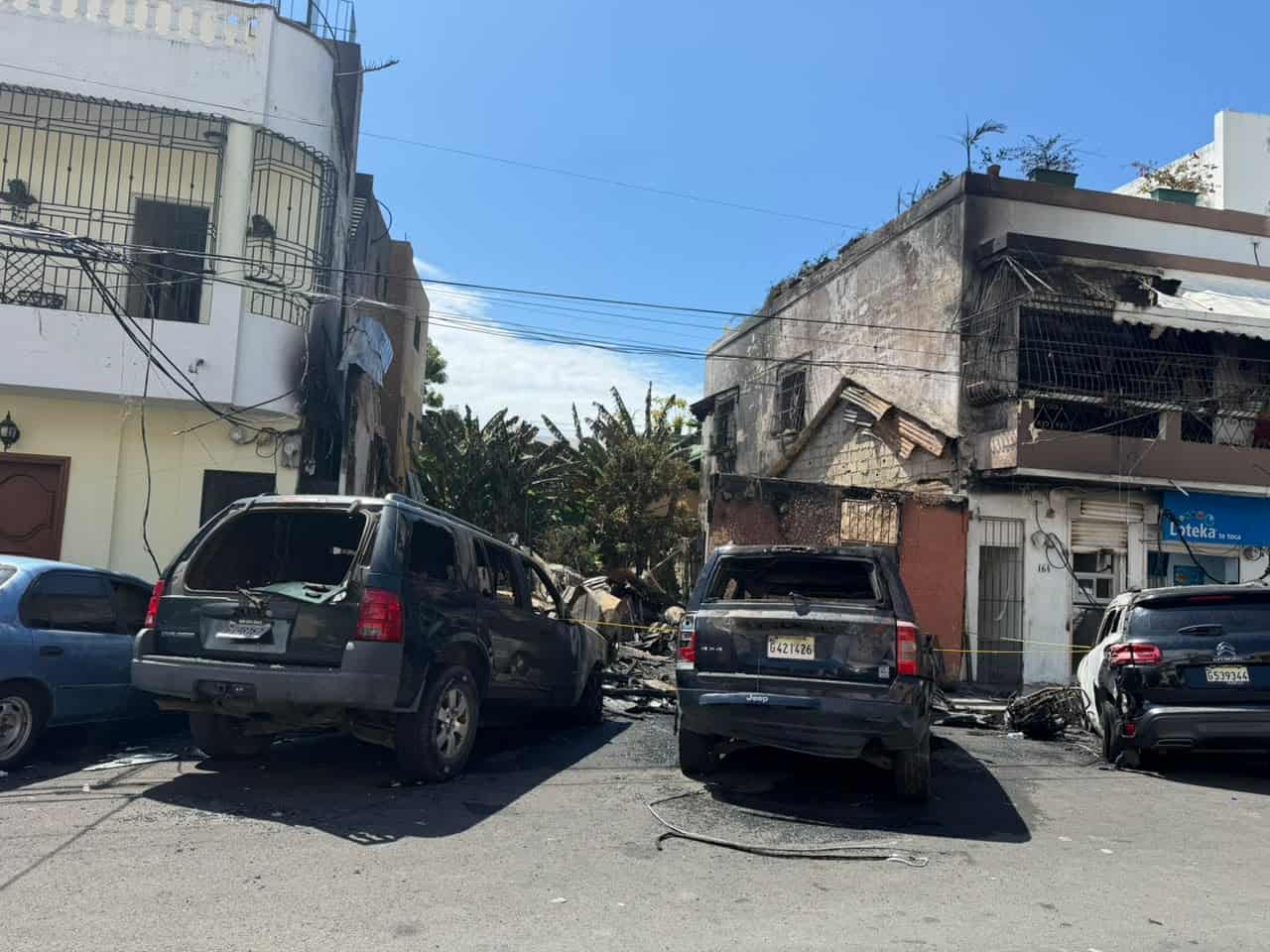 Vehículos frente al terreno donde se incendió la vivienda en la Ciudad Colonial.