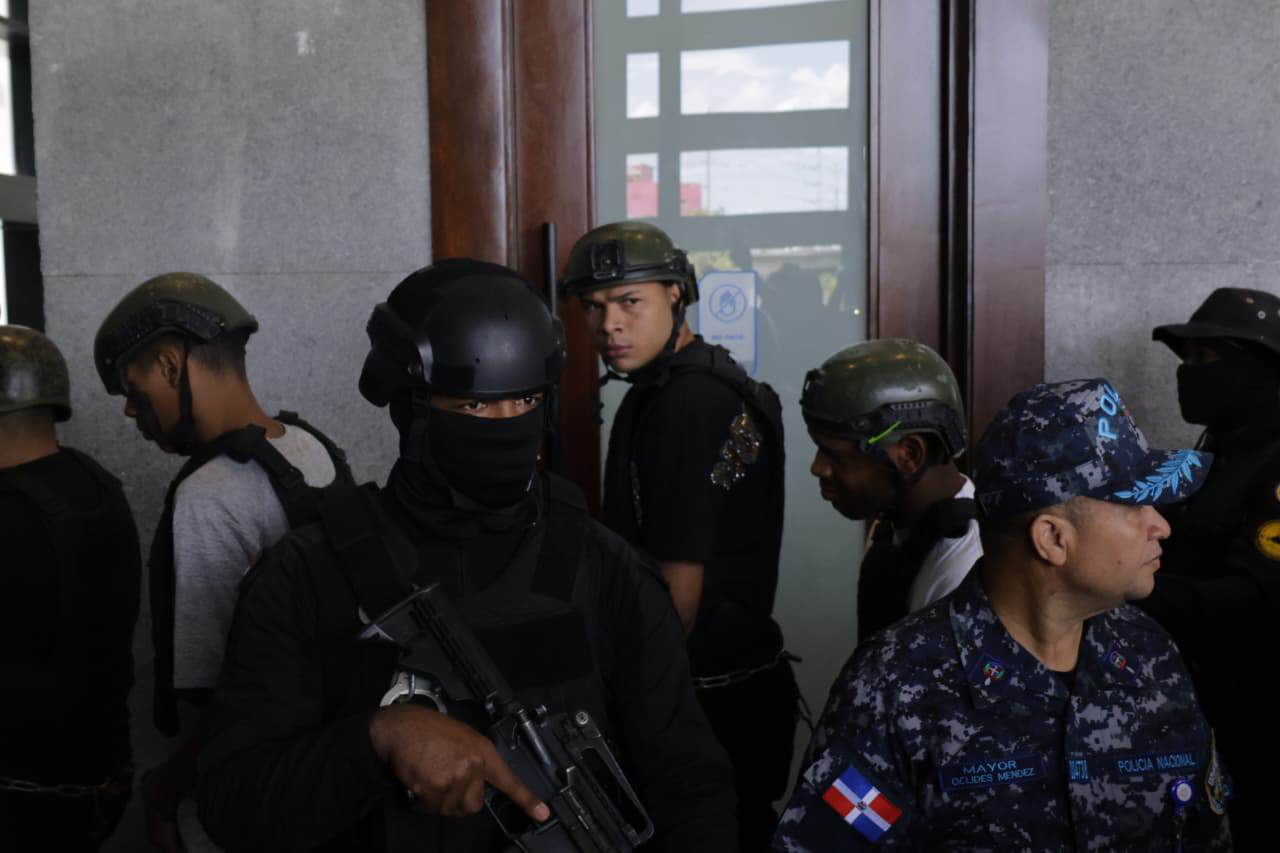 Uno de los imputados voltea hacia atrás durante su traslado al tribunal, bajo un amplio dispositivo de seguridad.